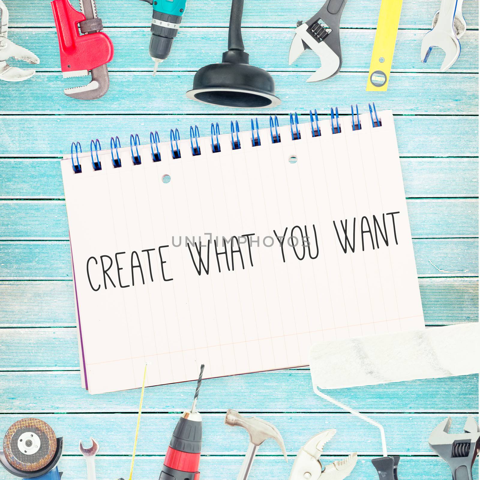 The word create what you want against tools and notepad on wooden background