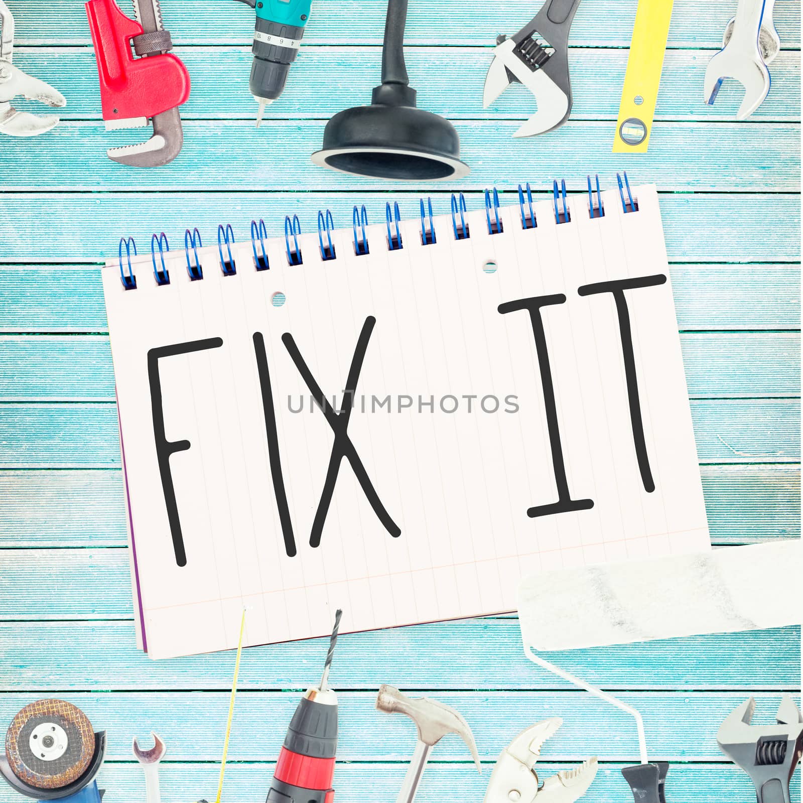 The word fix it against tools and notepad on wooden background