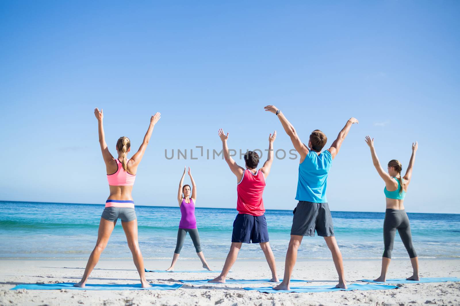 Friends doing yoga together with their teacher  by Wavebreakmedia