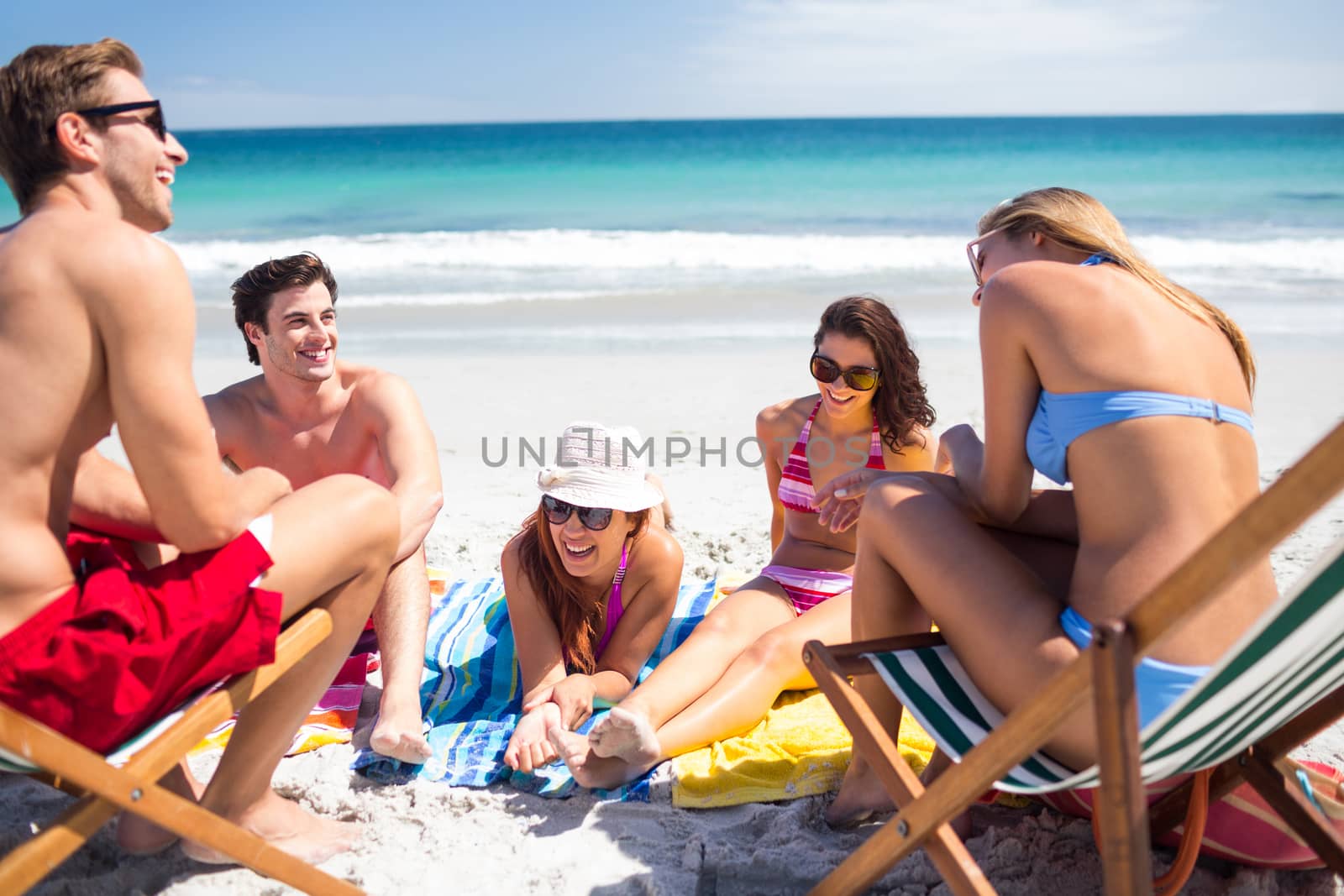 Happy friends sunbathing together at the beach