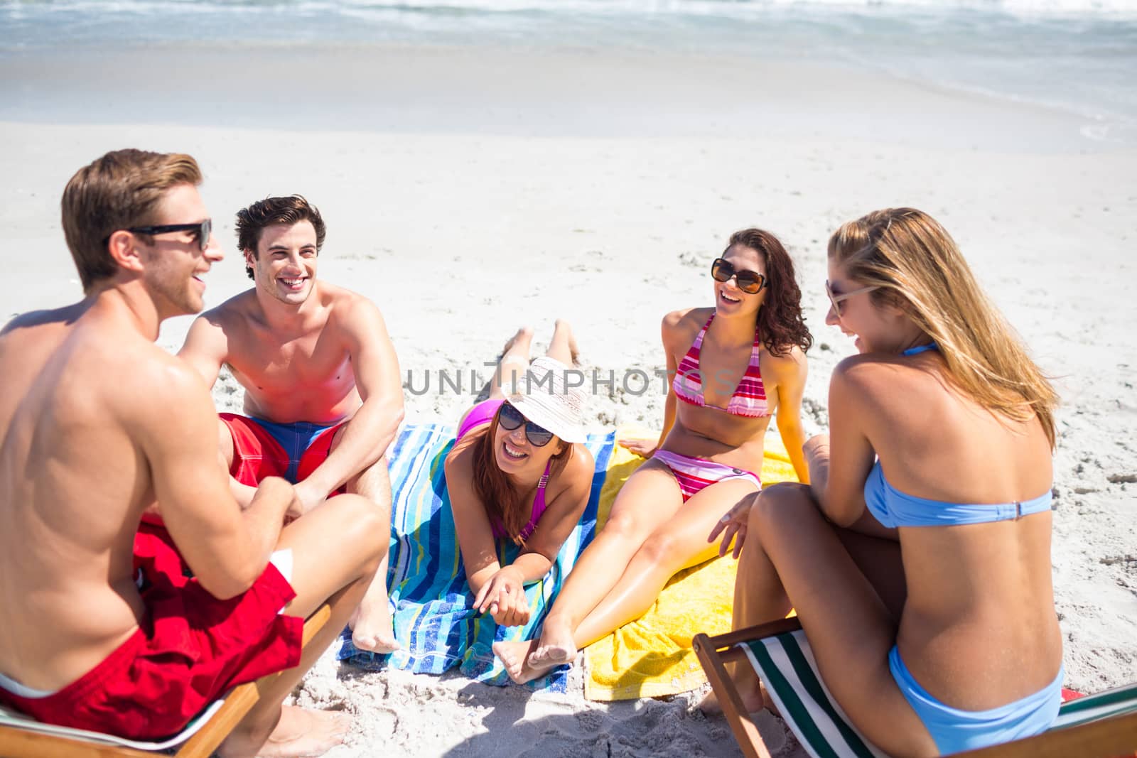 Happy friends sunbathing together by Wavebreakmedia
