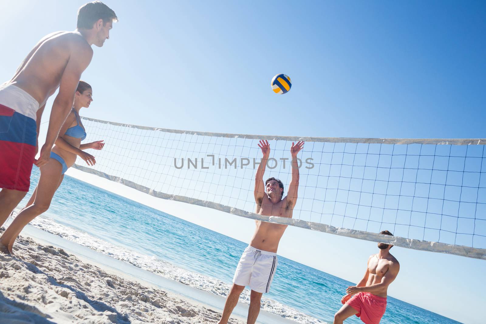 Friends playing volleyball by Wavebreakmedia