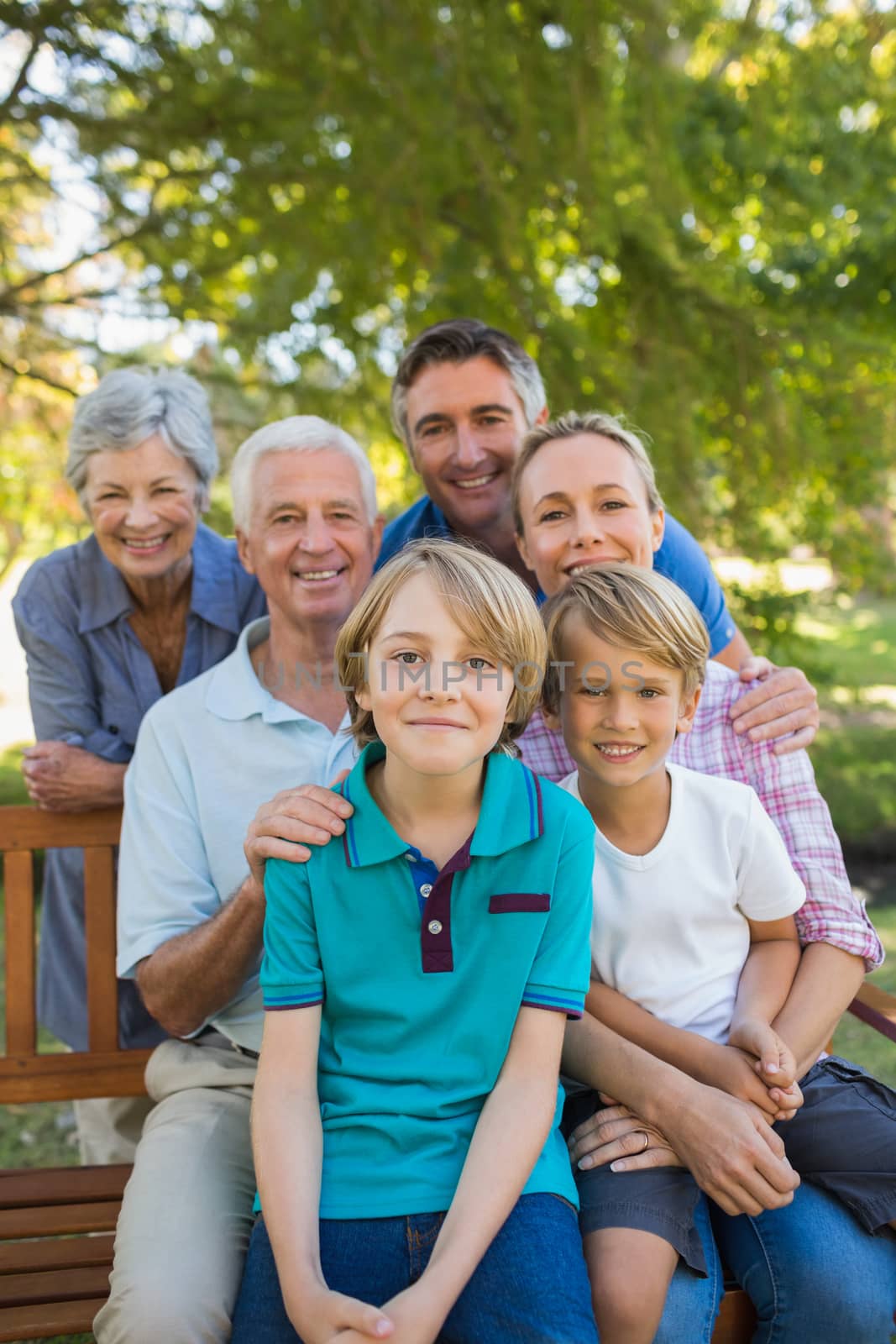 Happy family smiling at the camera on a sunny day