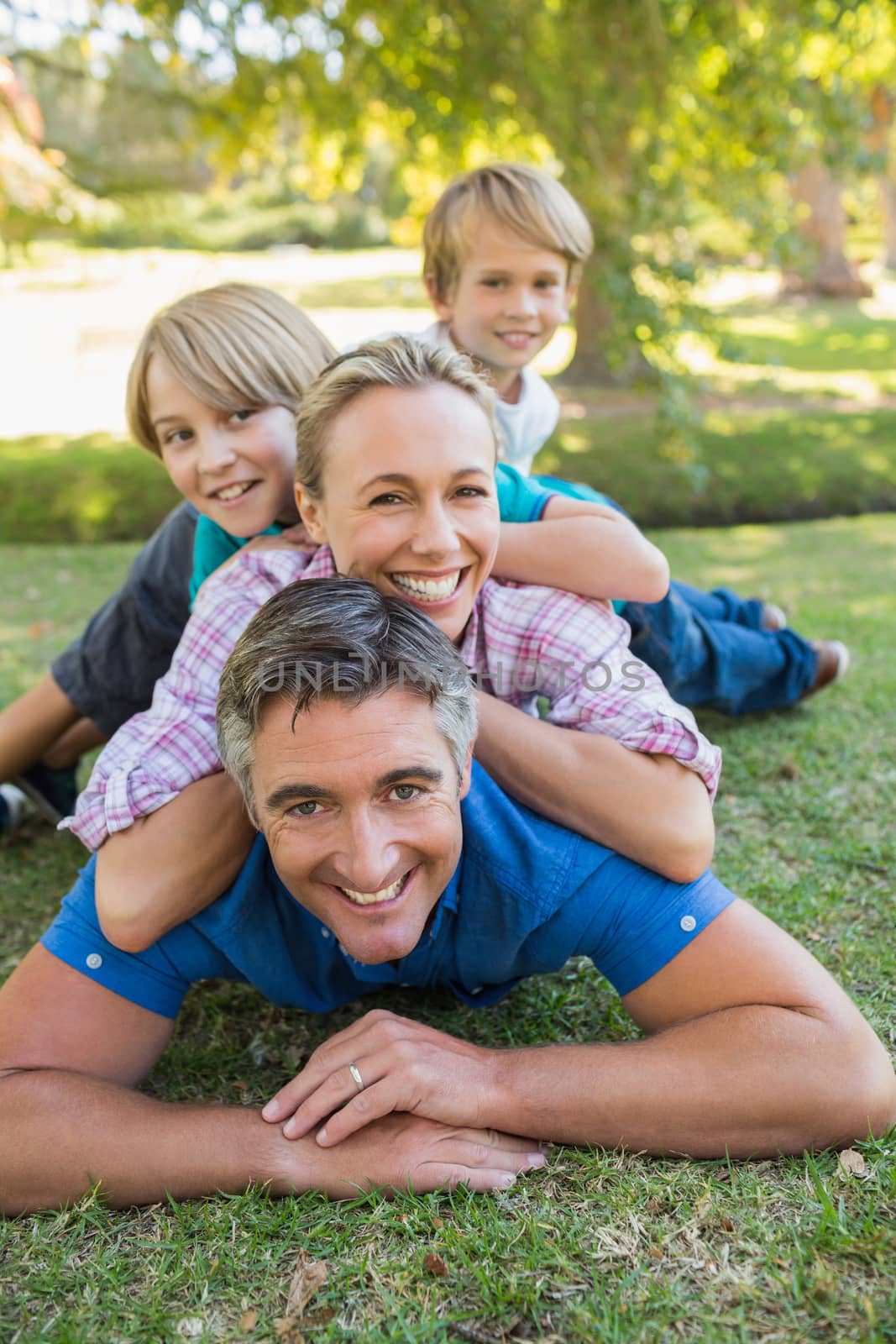 Happy family smiling at the camera on a sunny day