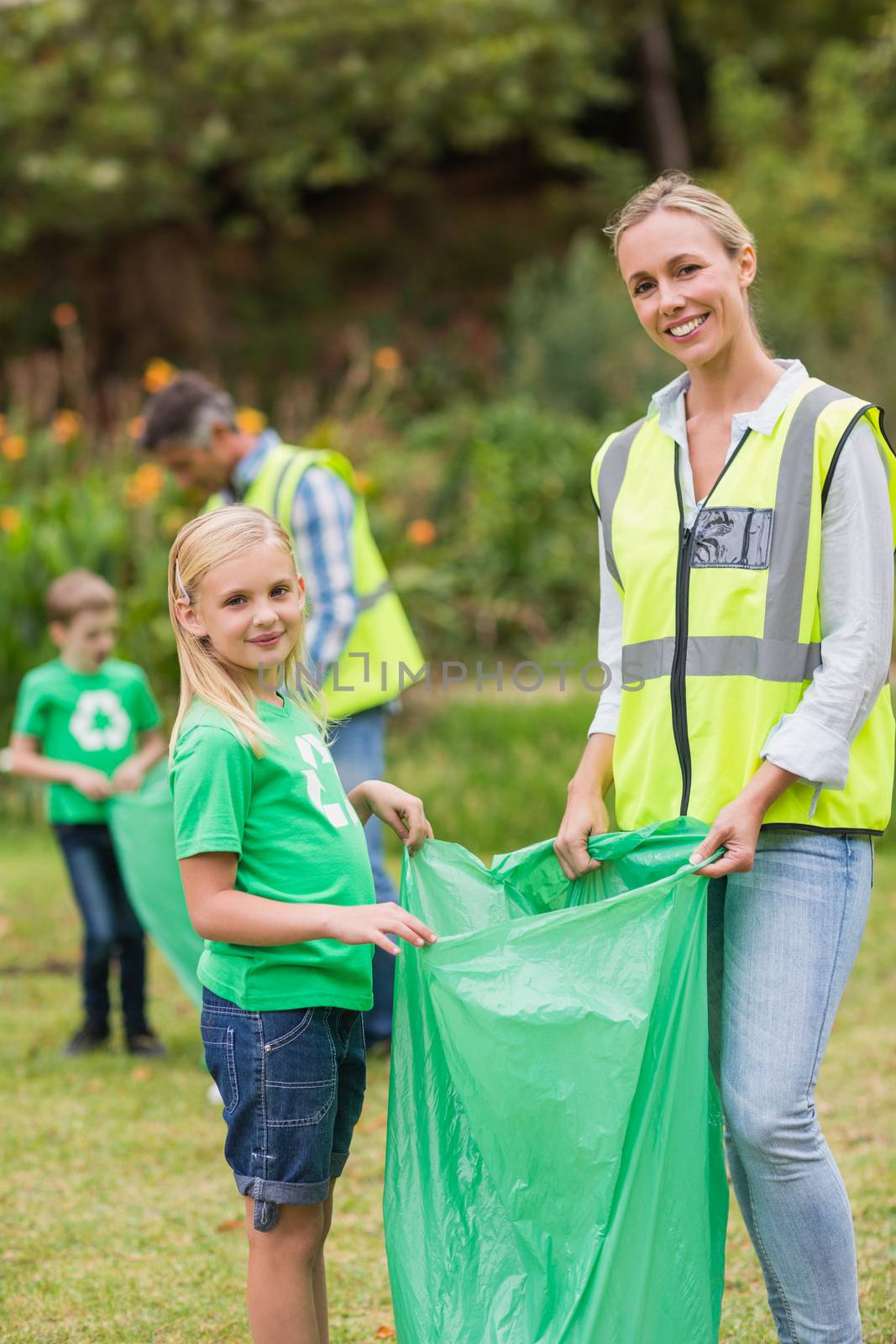 Happy family collecting rubbish on a sunny day