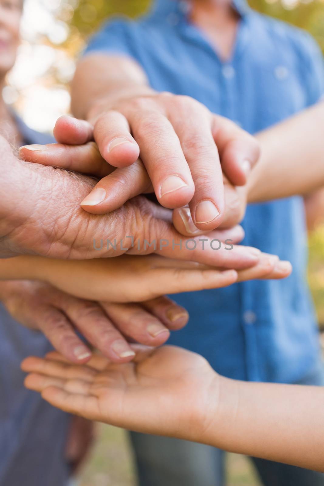 Family putting their hands together on a sunny day