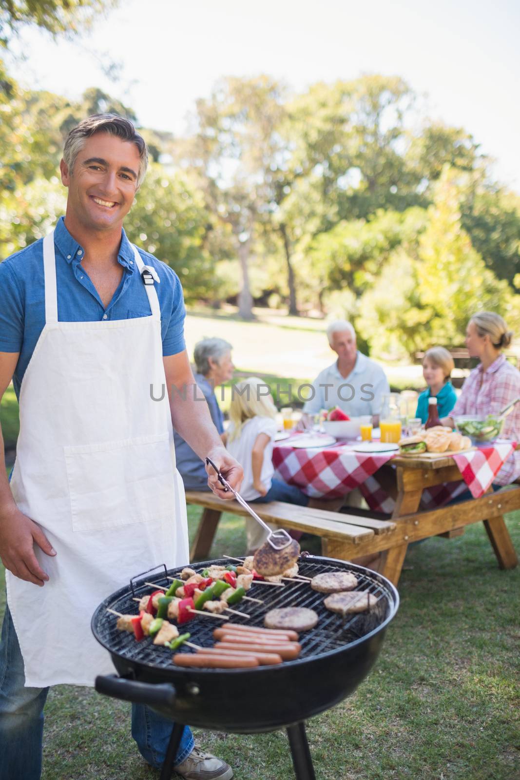 Happy man doing barbecue for his family by Wavebreakmedia