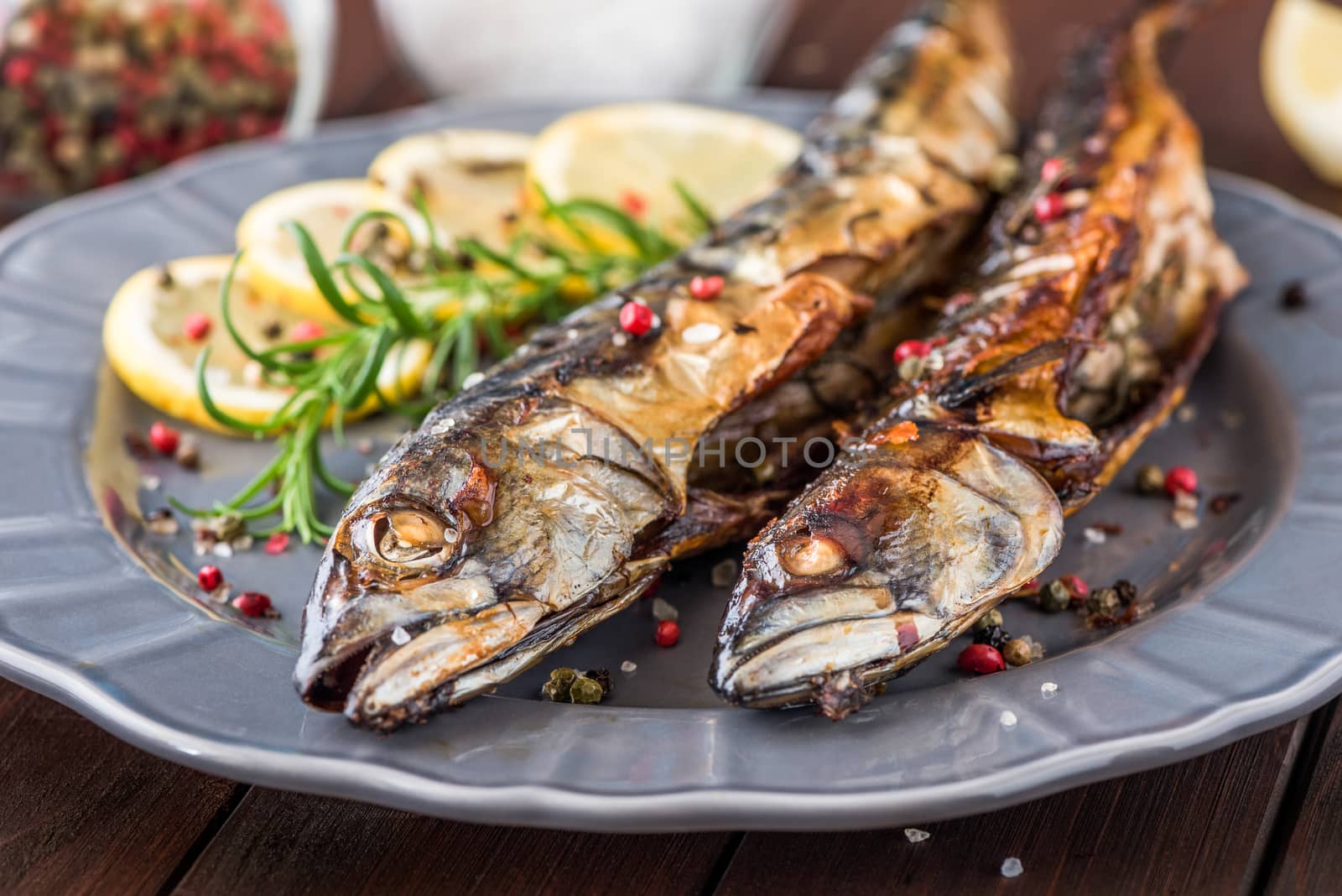 Baked Whole Mackerel Fish with Spice, Lemon and Rosemary on a Plate on Wooden Table