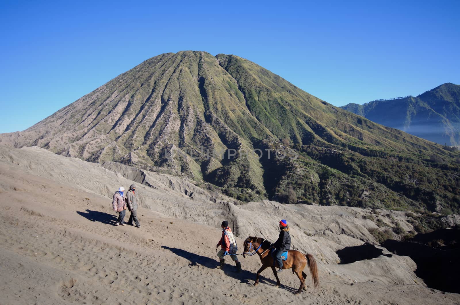 Undefined model posing on a horse under the Bromo massif. Mount Bromo is an active volcano and part of the Tengger massif, in East Java. June 28, 2014.