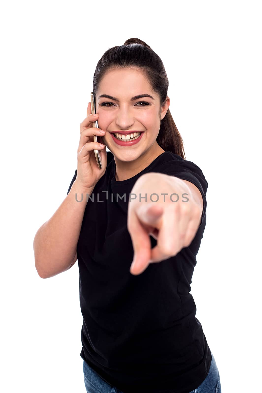 Woman talking on cell phone and pointing to camera