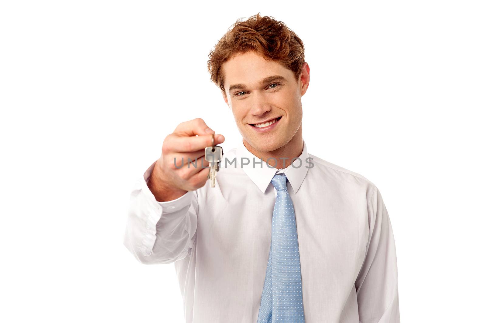 Smiling male realtor offering new house key