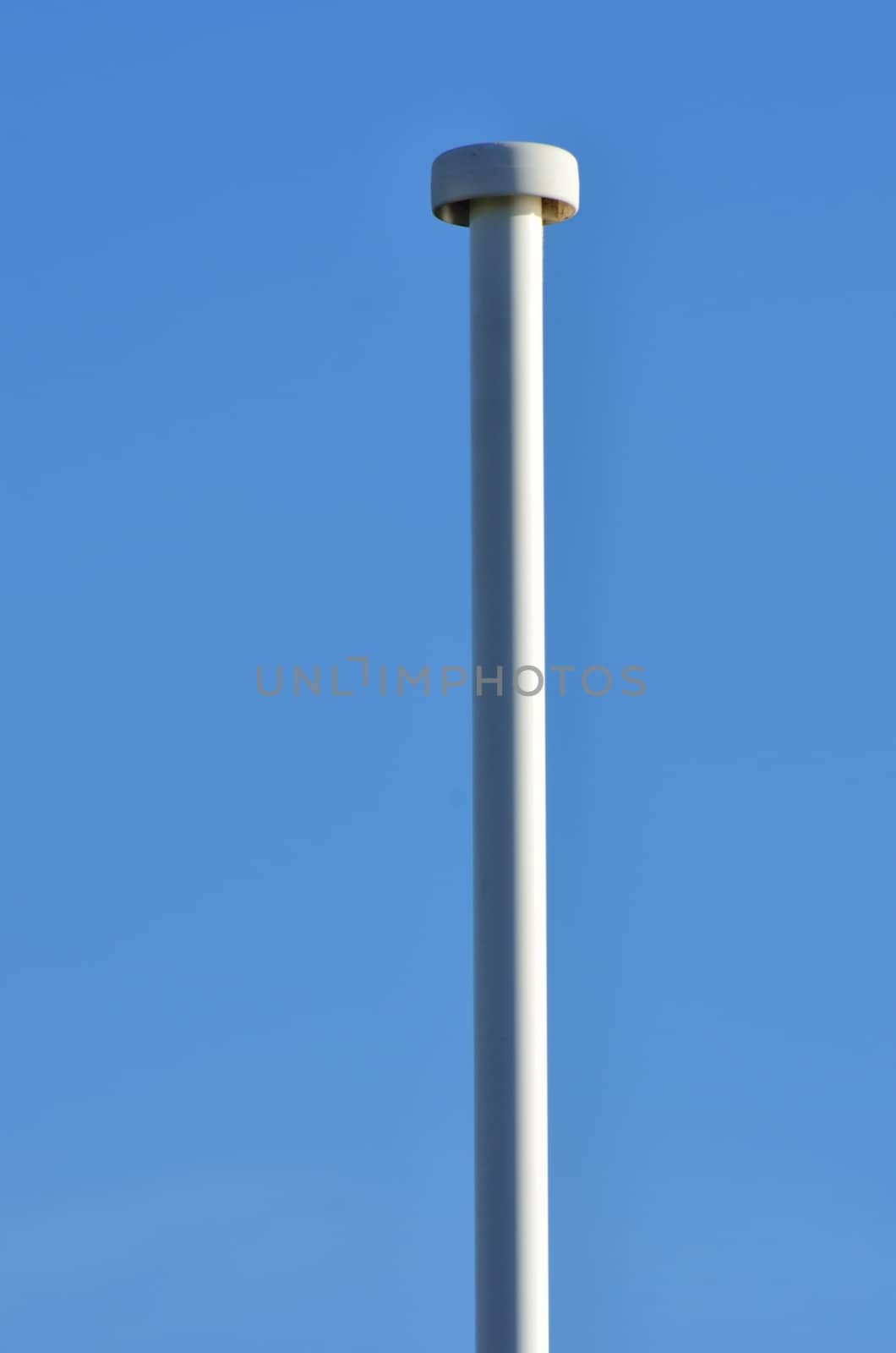 Empty lampost with blue sky in background