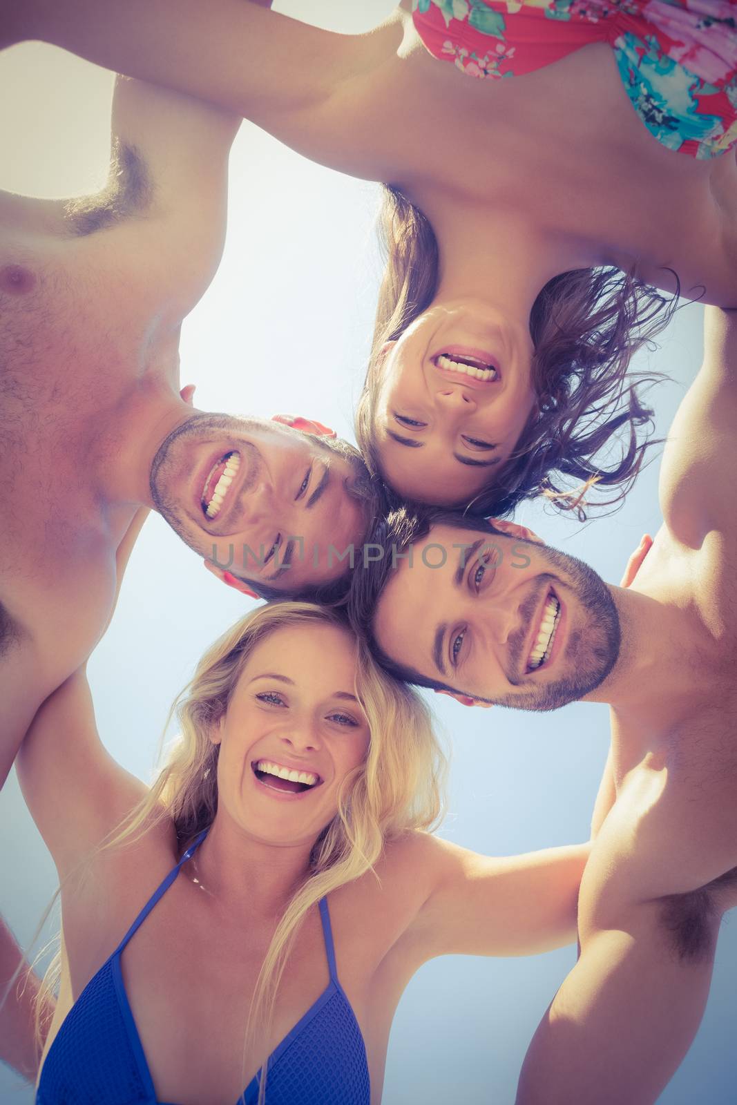 Happy friends smiling at camera on the beach