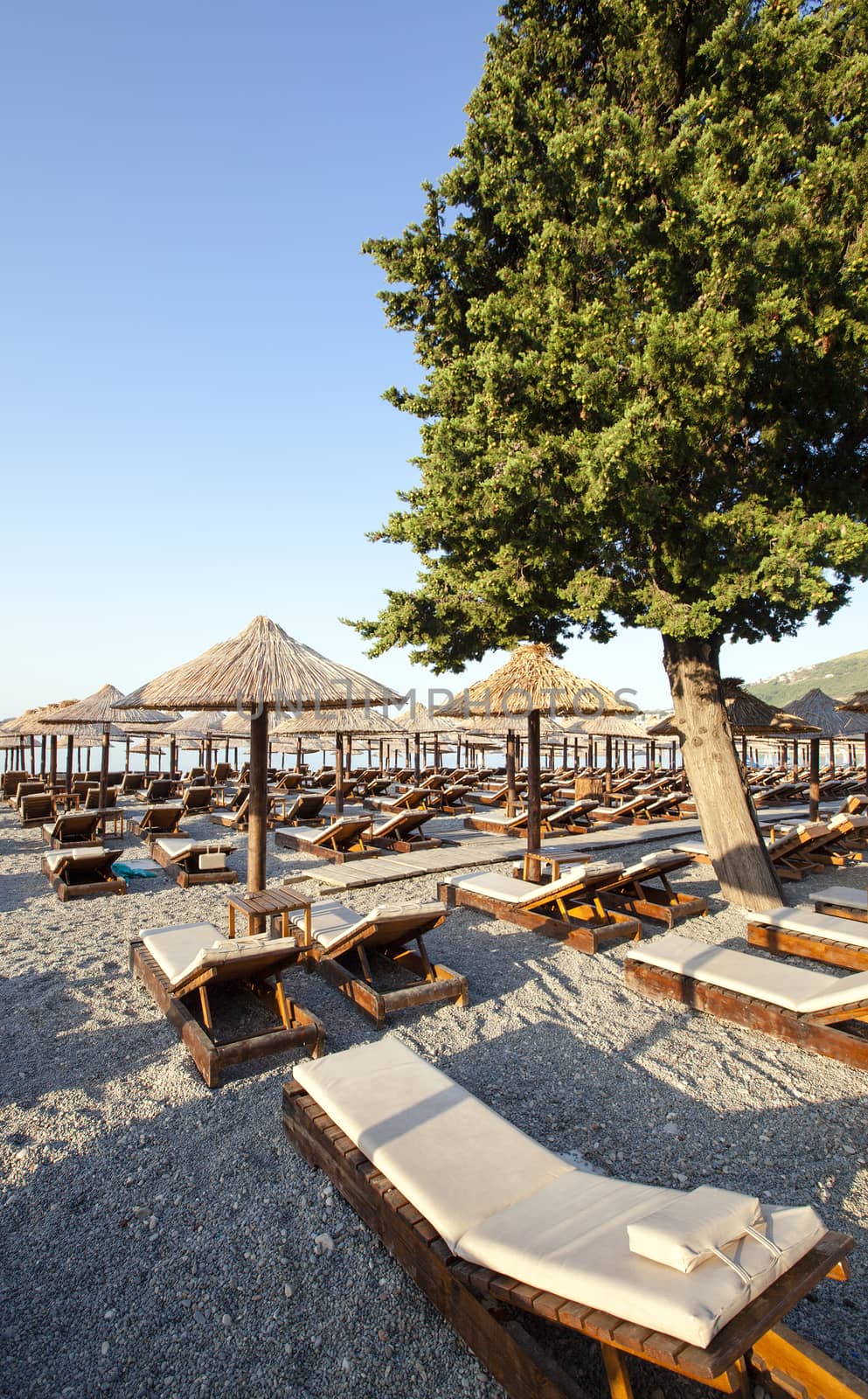   wooden plank beds for rest on a beach. pebble beach