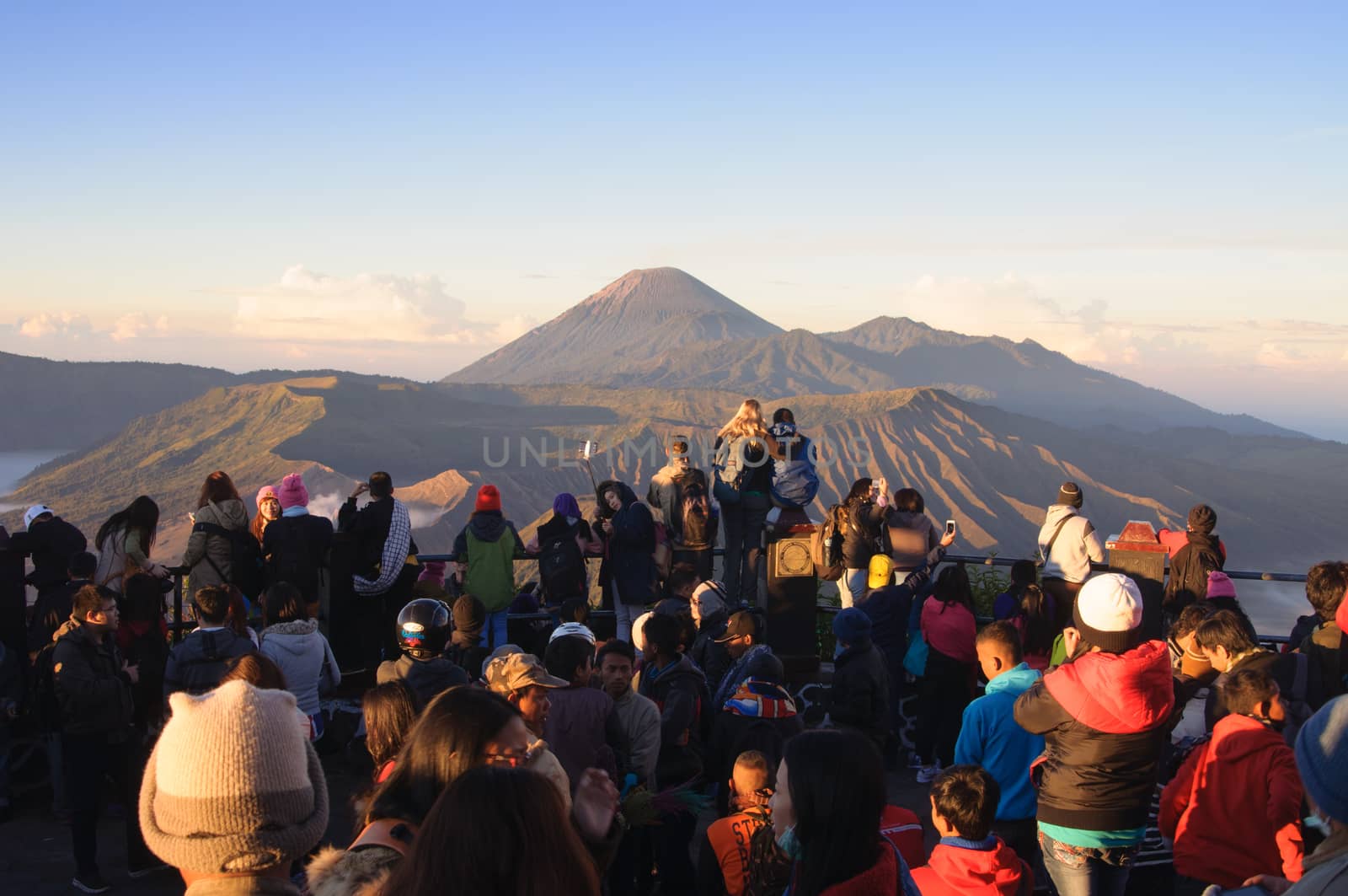 MOUNT BROMO, INDONESIA - JUNE 28, 2014: Undefined crowd of tourists watching sunrise over Bromo volcano by johnnychaos