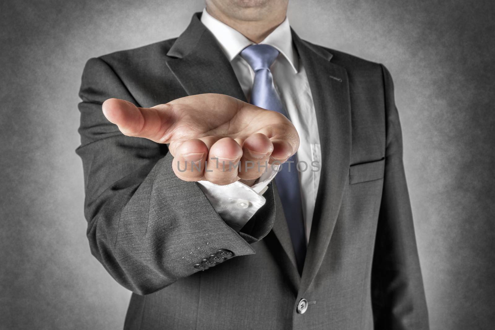 Businessman in dark suit holds out his hand