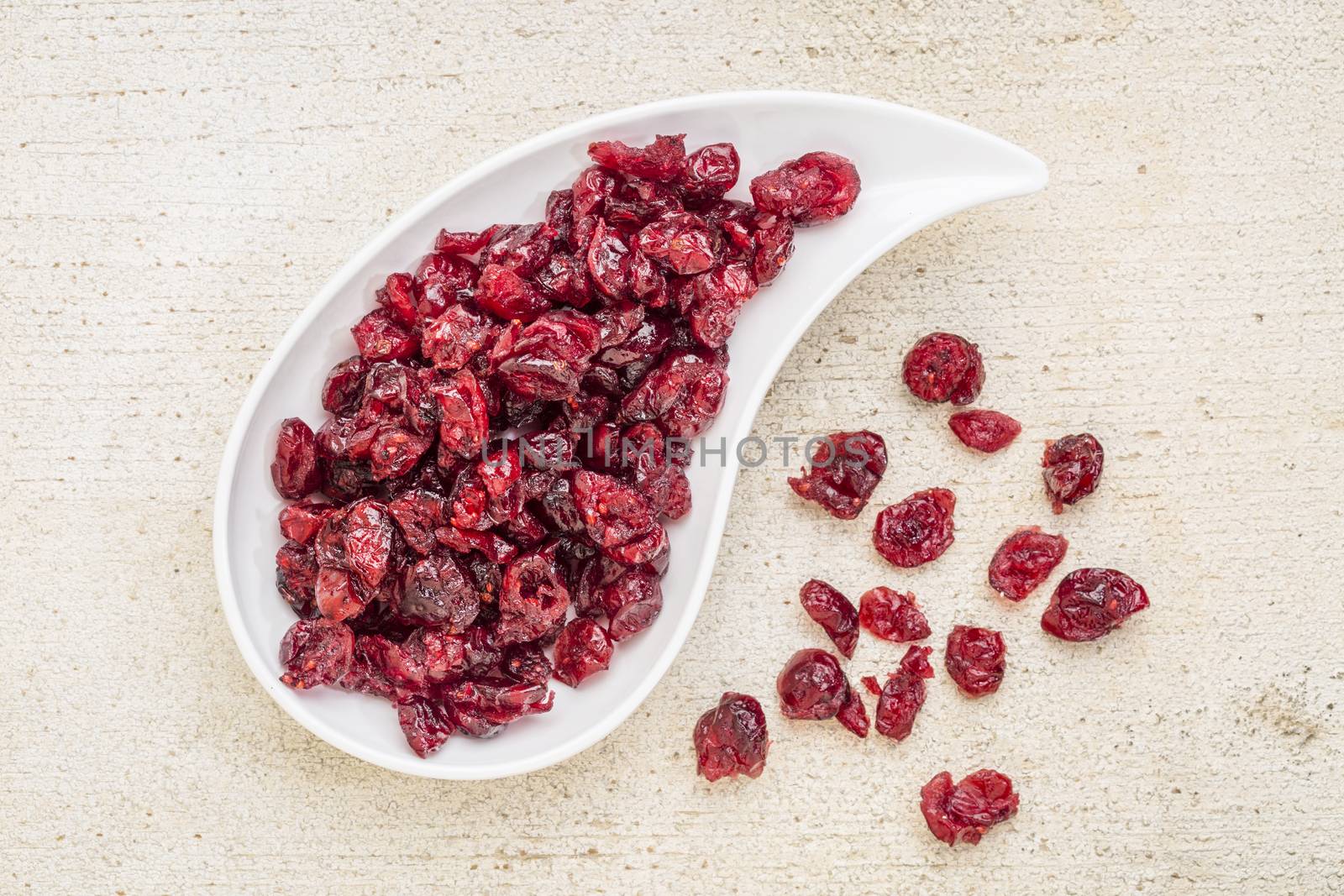 dried cranberry on a teardrop shaped bowl against a rustic barn wood