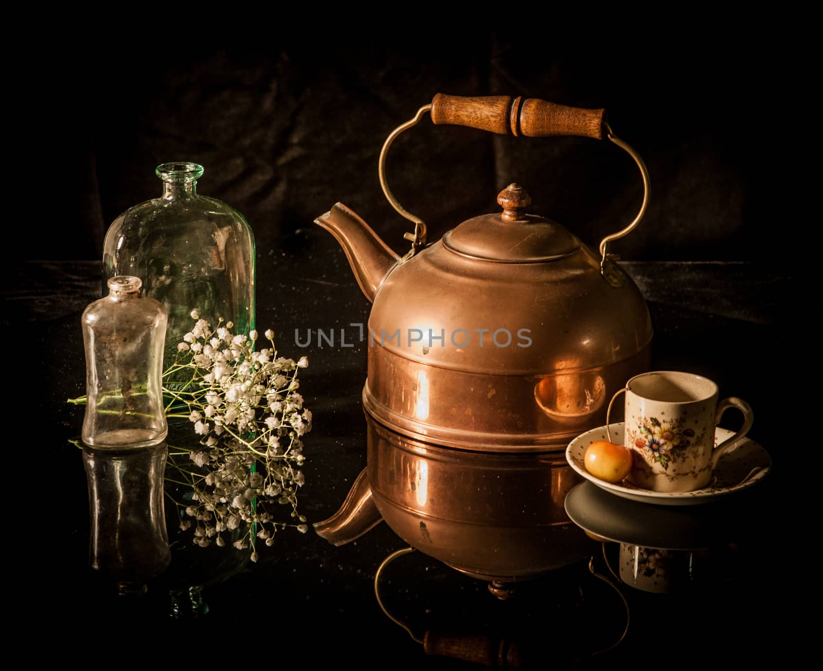 Still life with antique brass tea pot, coffee cup, flower, bottle