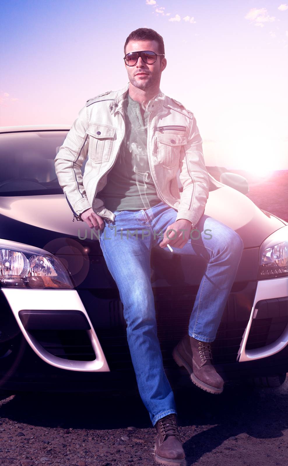 Young man portrait and car.Sunset landscape. Fashion and motor lifestyle.