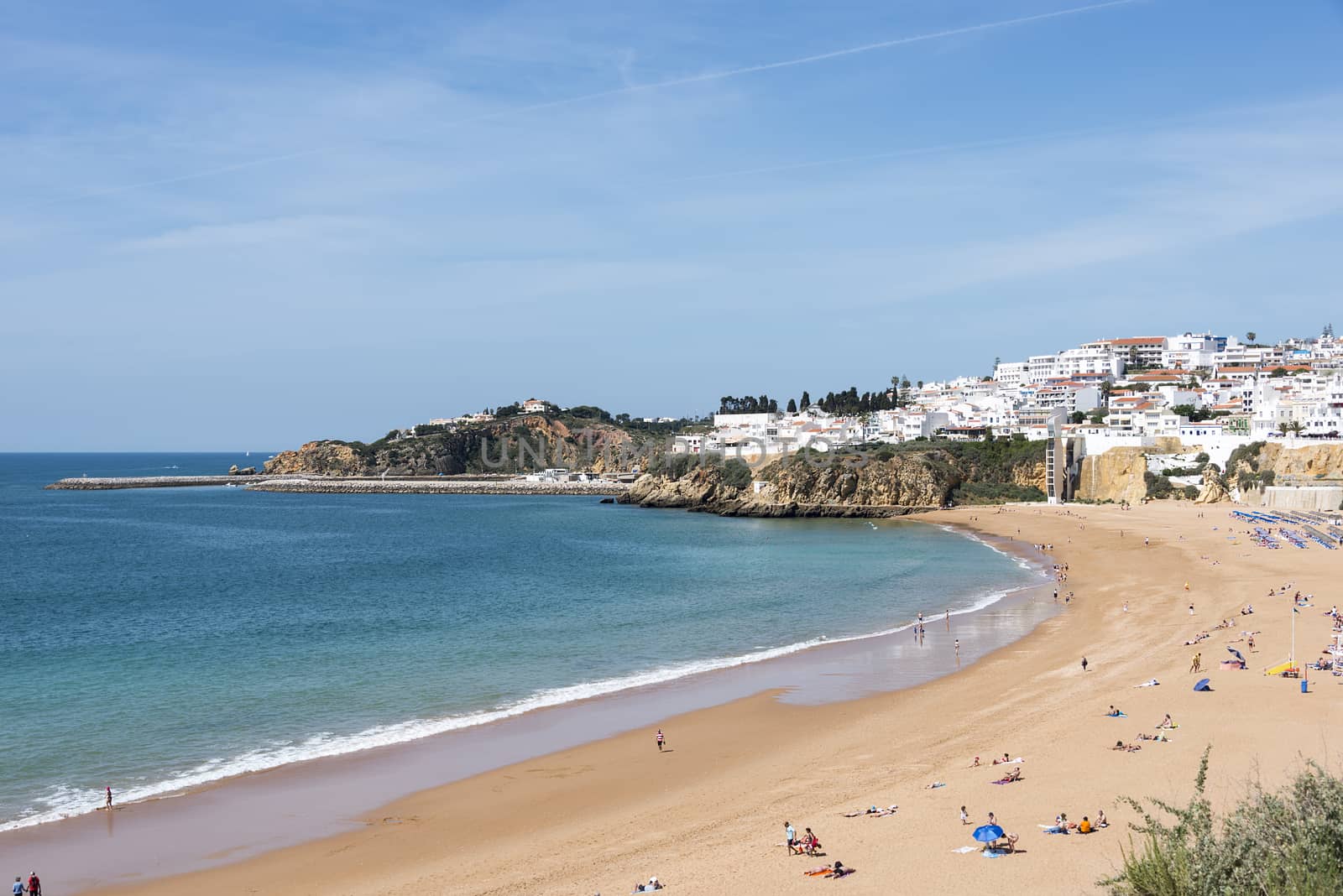 ALBUFEIRA, PORTUGAL - APRIL 23: View of crowded Falesia beach at the midday in the summer mediterranean resort Albufeira on April 23, 2015. This town is a part of famous tourist region Algarve.
