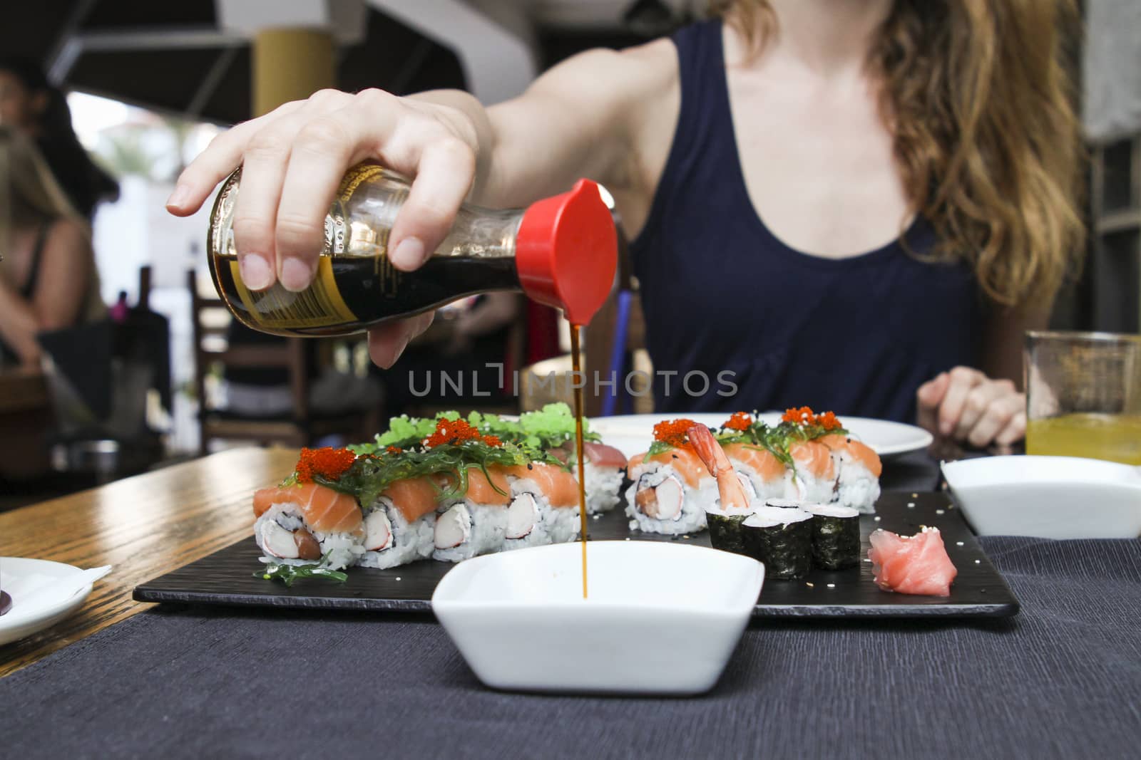 woman pour soya sauce in white  ceramic bowl