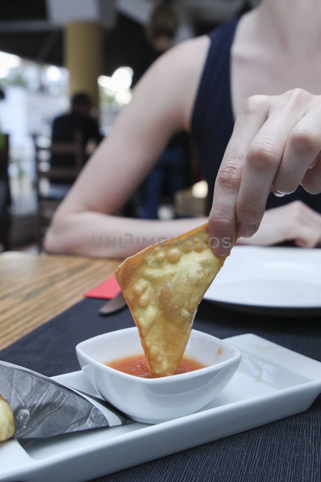 dipping fried pancake in spicy sauce