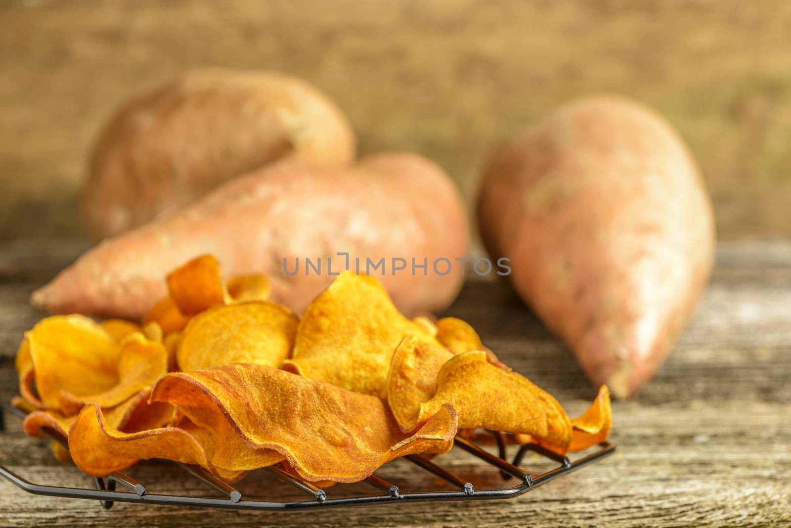 Fresh homemade sweet potato chips on a rustic background.