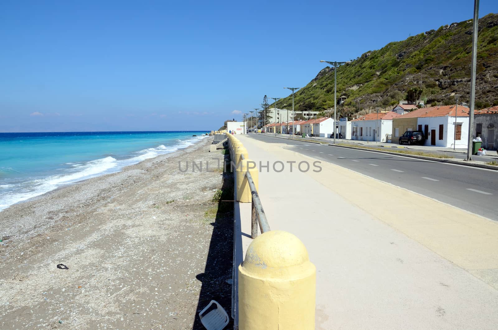 Turquoise Aegon sea at western part of Rhodes city, Ialisou street with small Greek houses. 