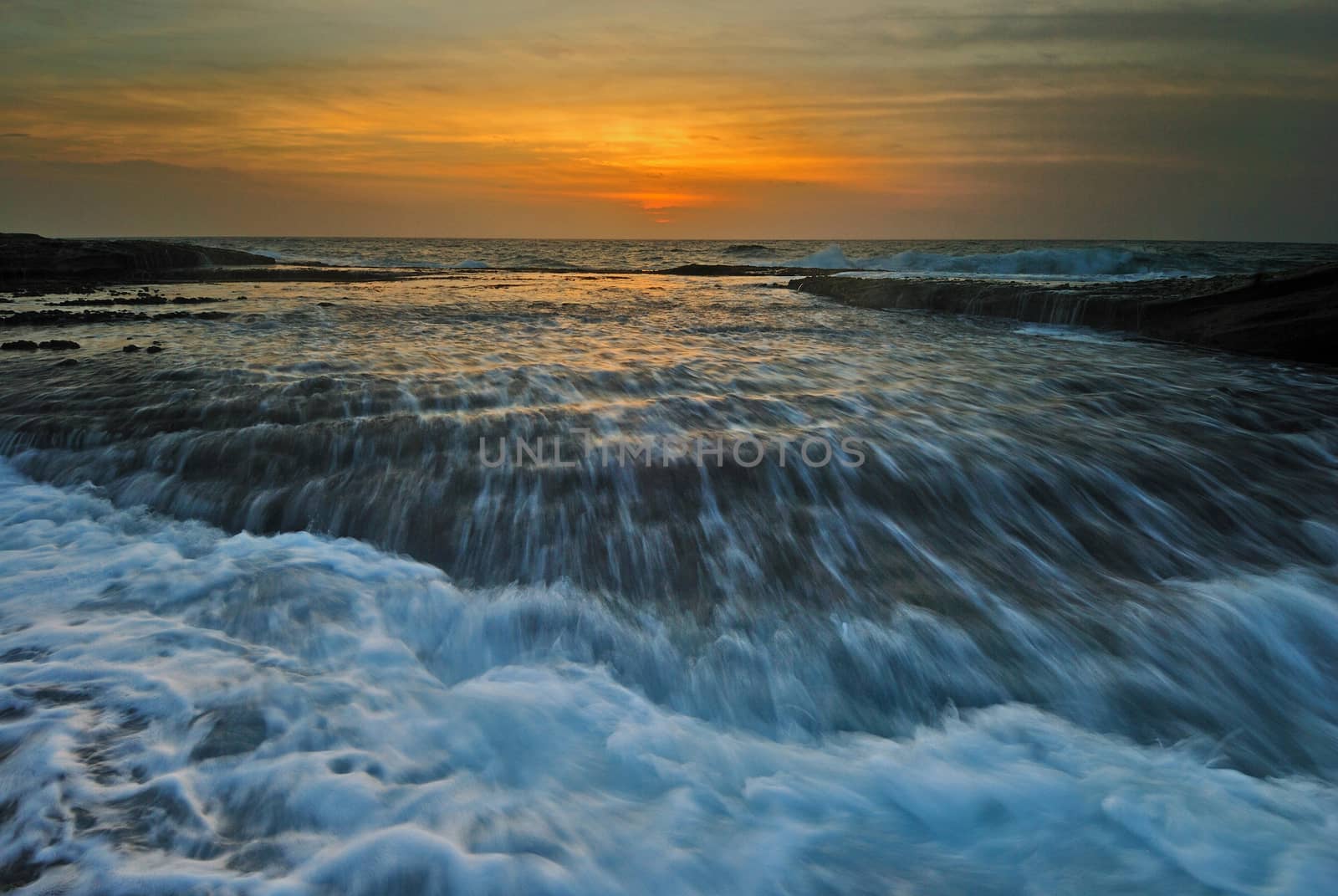 Sunrise seascape with rushing waves