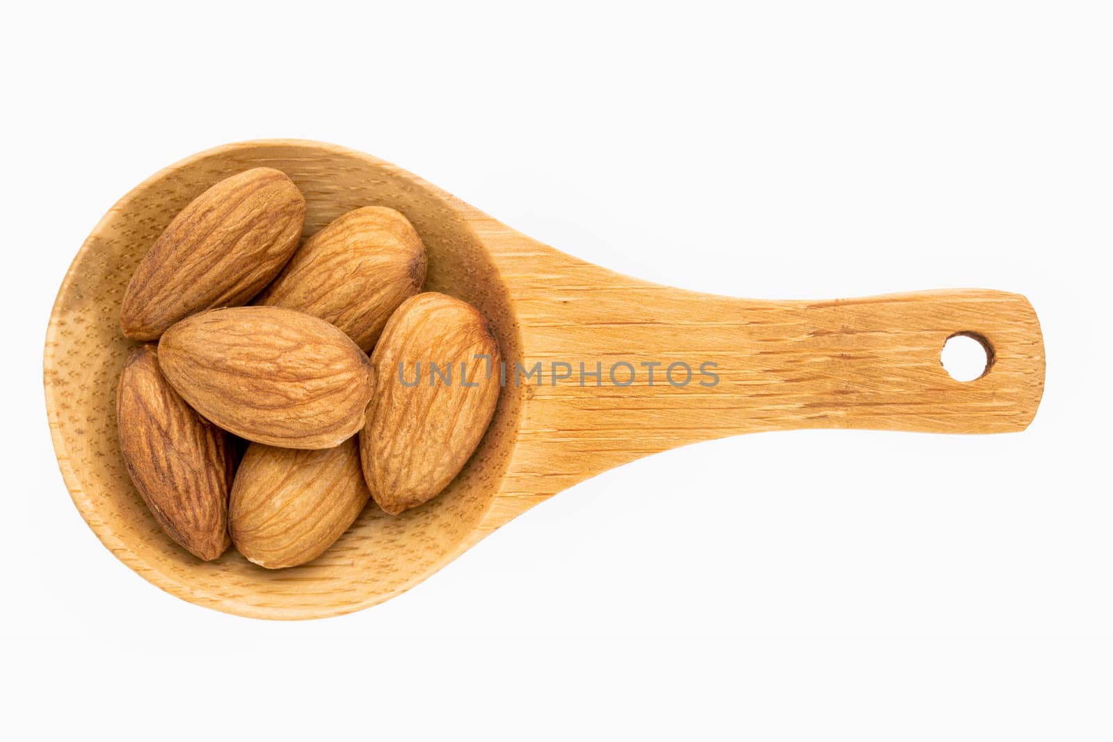 almond nut on a small wooden spoon isolated on white with a clipping path