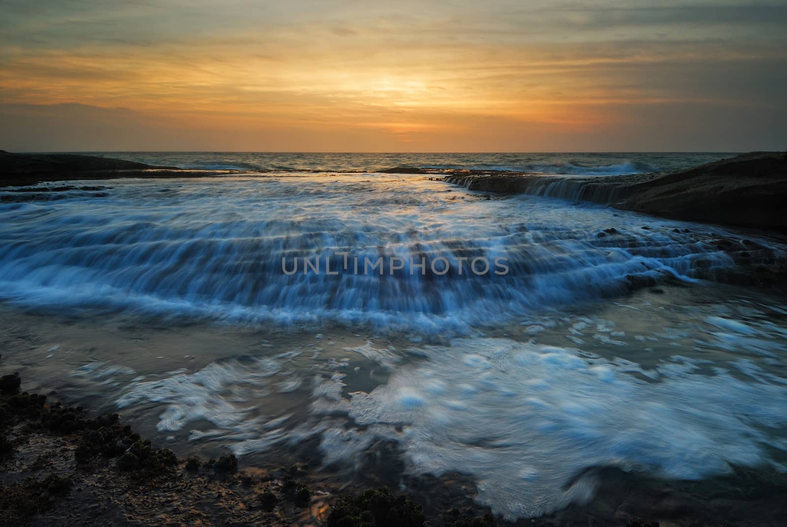 Sunrise seascape with rushing waves