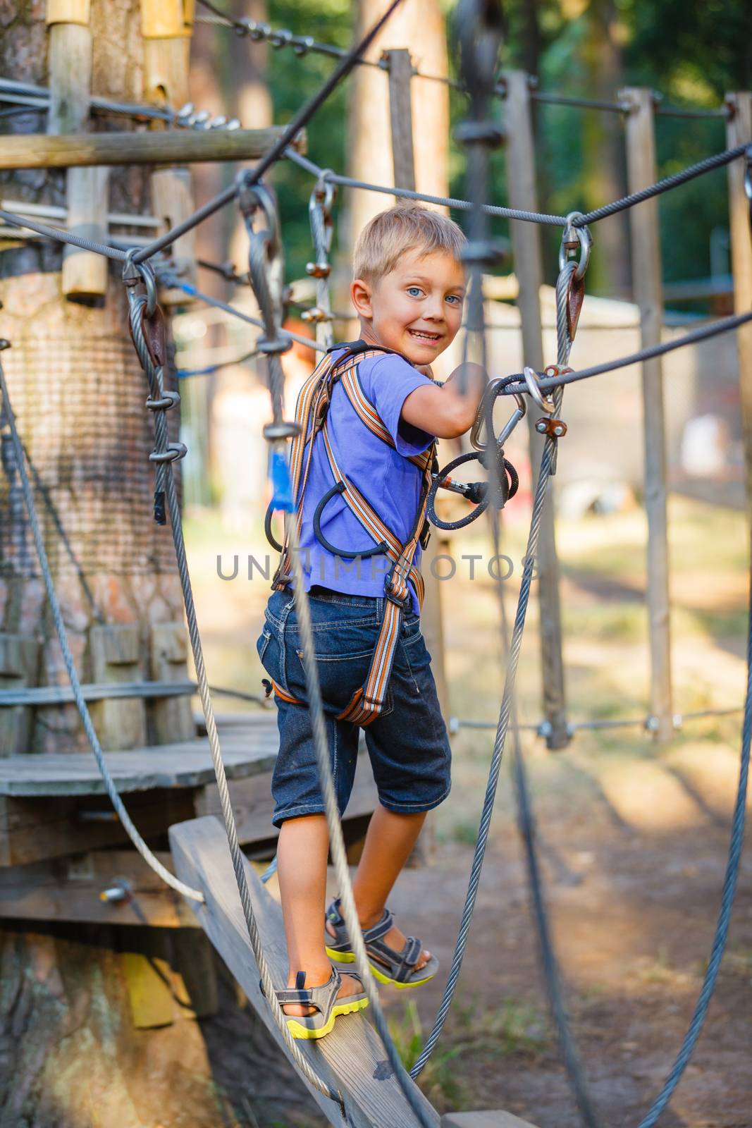 Boy in a climbing adventure park by maxoliki