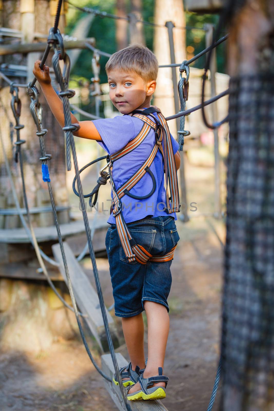 Boy in a climbing adventure park by maxoliki