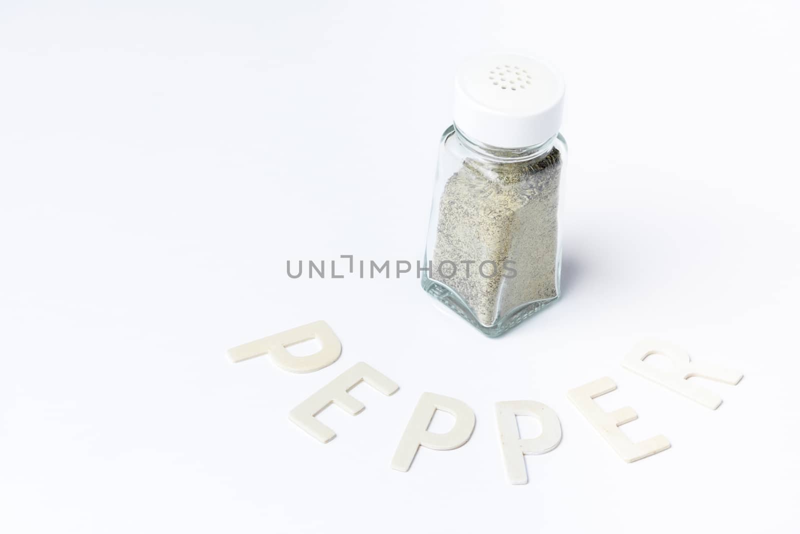 Pepper in glass container on white background