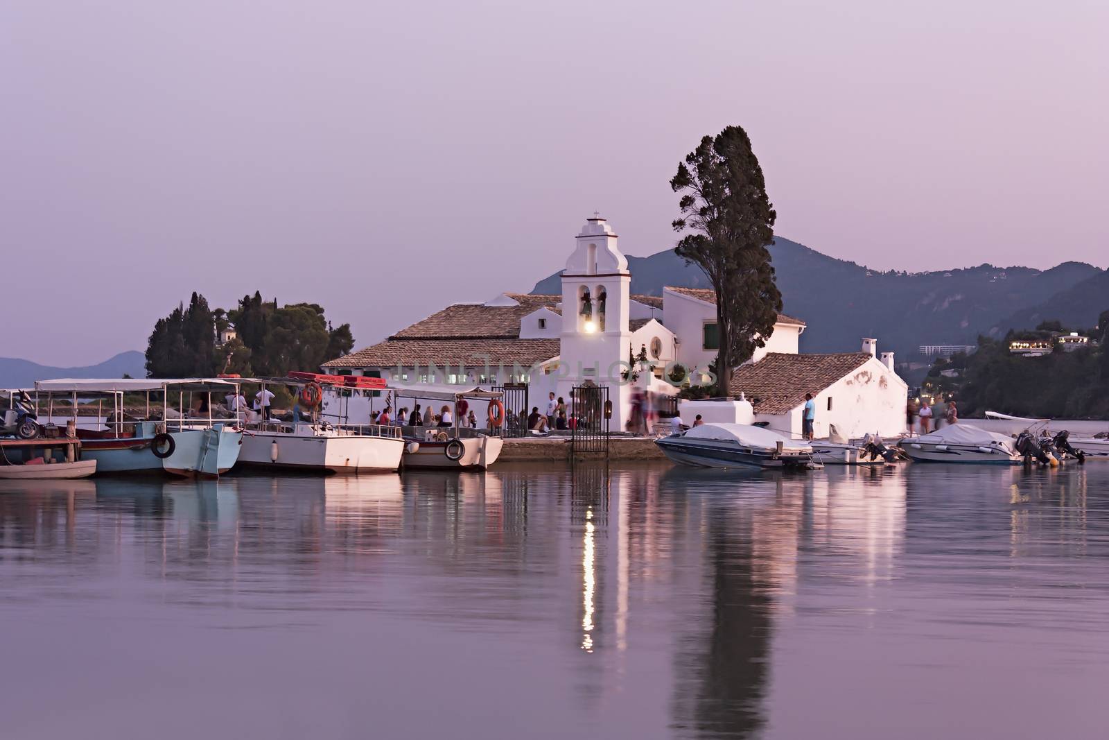 Located south of the city and in the southern part of the peninsula of Kanoni there is a small monastery dedicated to Our Lady of Vlaherna. 
It almost seems that arise in the middle of the sea because it is on a small island connected to the mainland only by a small jetty. 
This all white architecture that stands out against the blue background of the sea dates back to the seventeenth century and the position in which is creates the perfect backdrop for a photograph. 
You enter through an arch to the base of the tower, and leads to a small courtyard which then passes into the church itself.