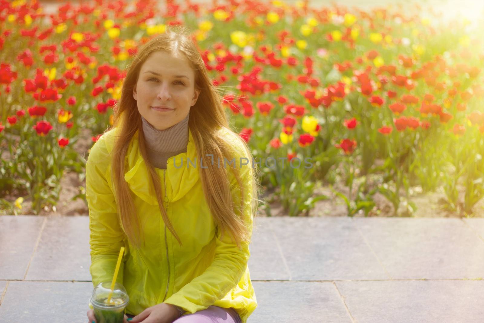 girl sitting next to a flower bed by victosha