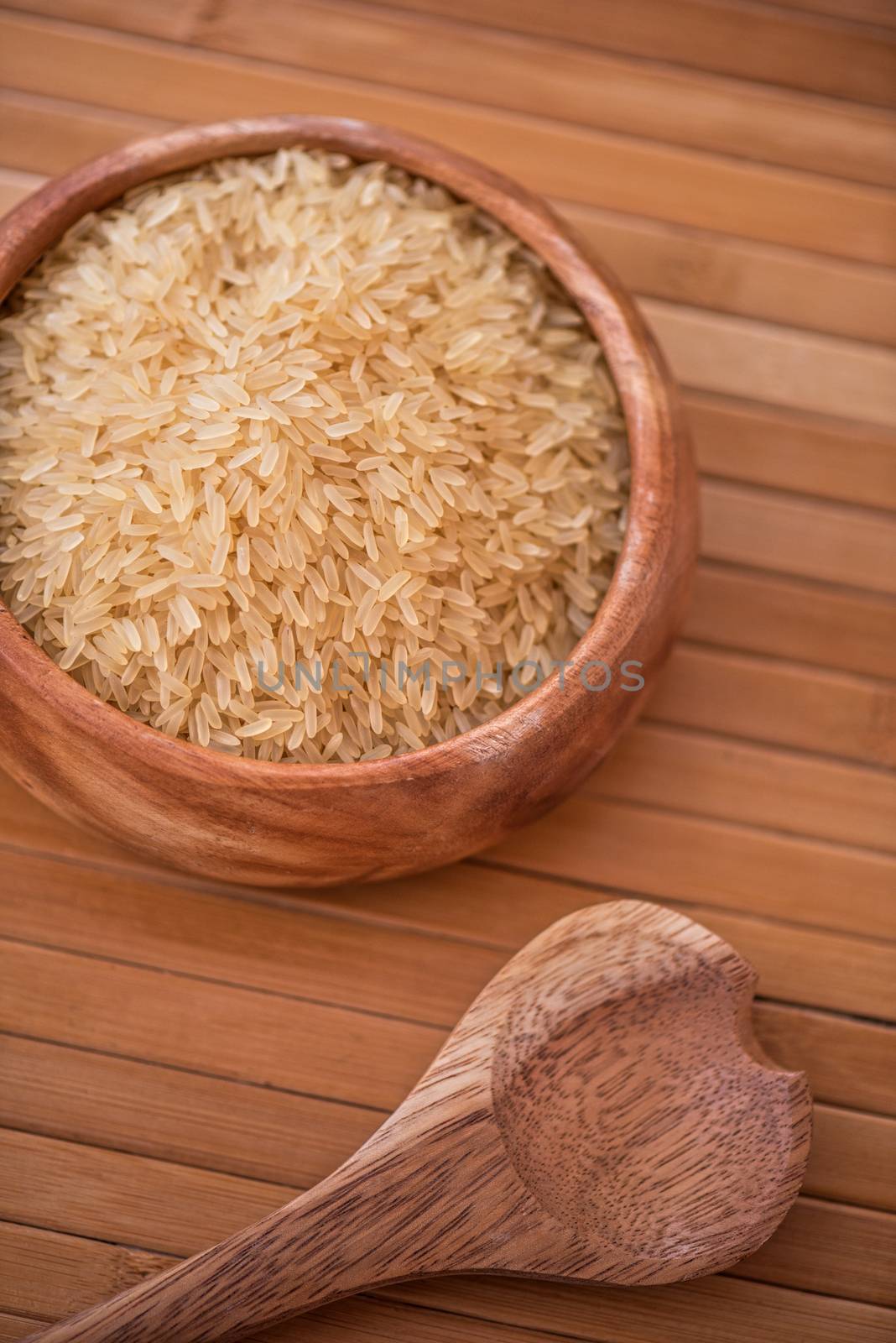 golden rice on wooden plate on wooden background