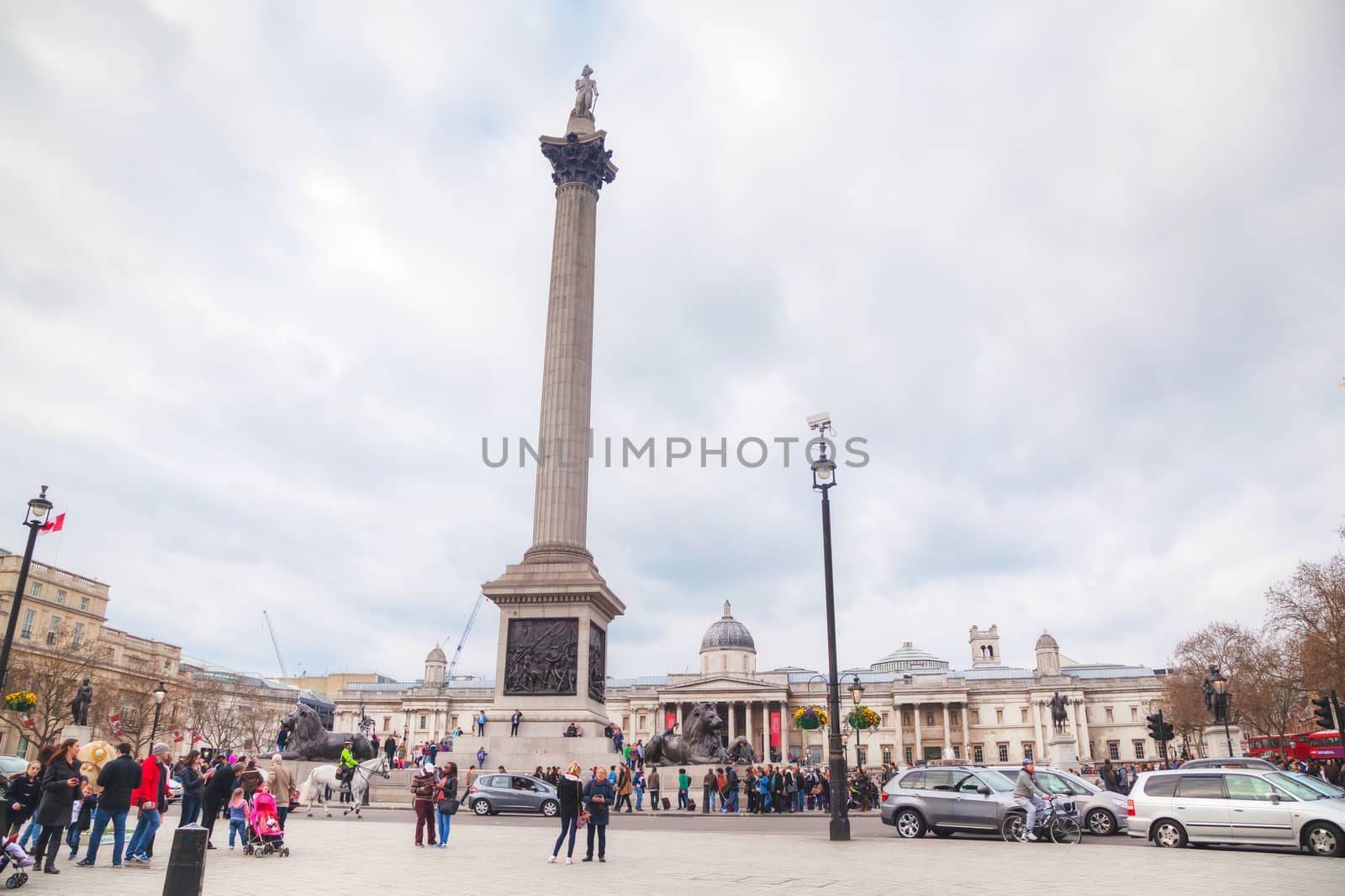 LONDON - APRIL 5: Trafalgar square with the Nelson's column on April 5, 2015 in London, UK. It's a public space and tourist attraction in central London, built around the area formerly known as Charing Cross.