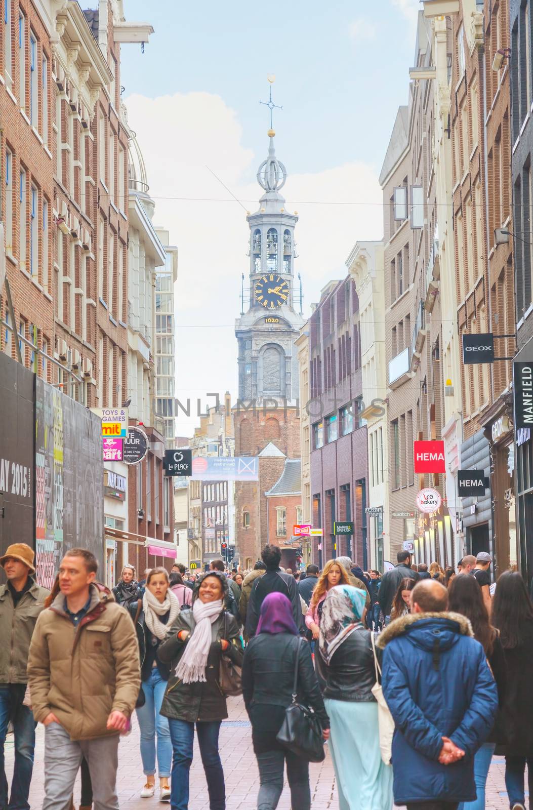 AMSTERDAM - APRIL 17: Narrow street crowded with tourists on April 17, 2015 in Amsterdam, Netherlands. It's the capital city and most populous city of the Kingdom of the Netherlands.