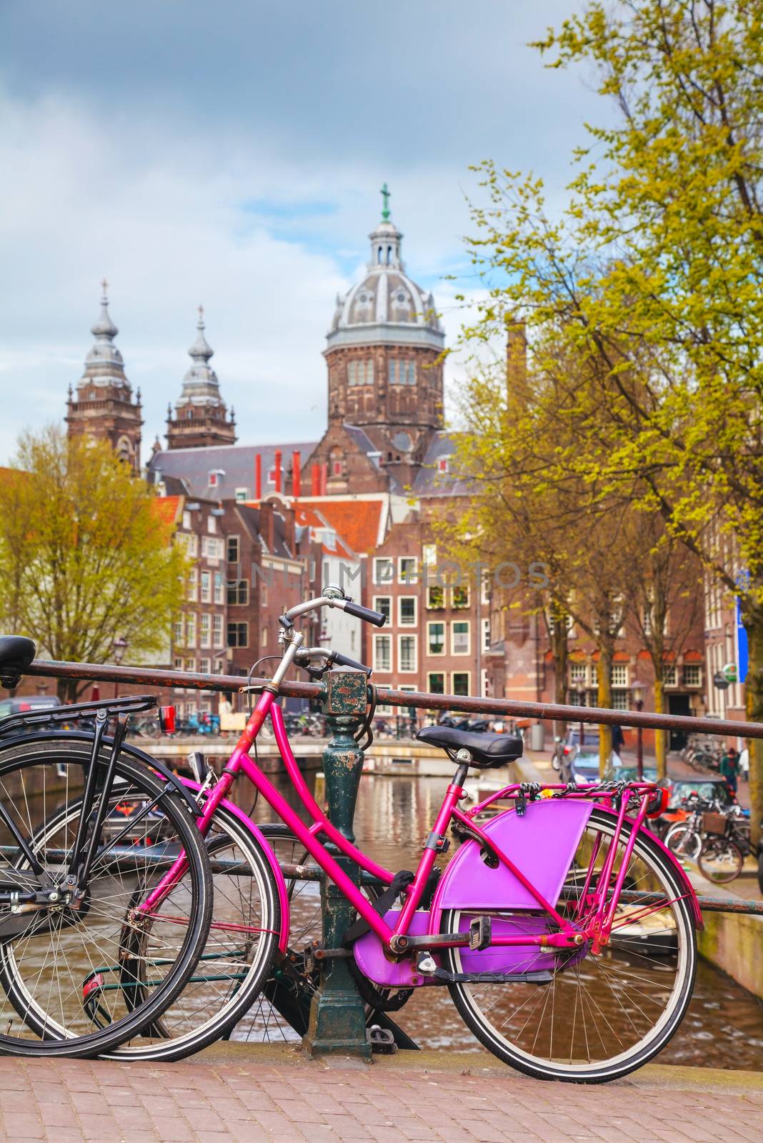 AMSTERDAM - APRIL 16: Bicycles parked at the bridge on April 16, 2015 in Amsterdam, Netherlands. It's the capital city and most populous city of the Kingdom of the Netherlands.