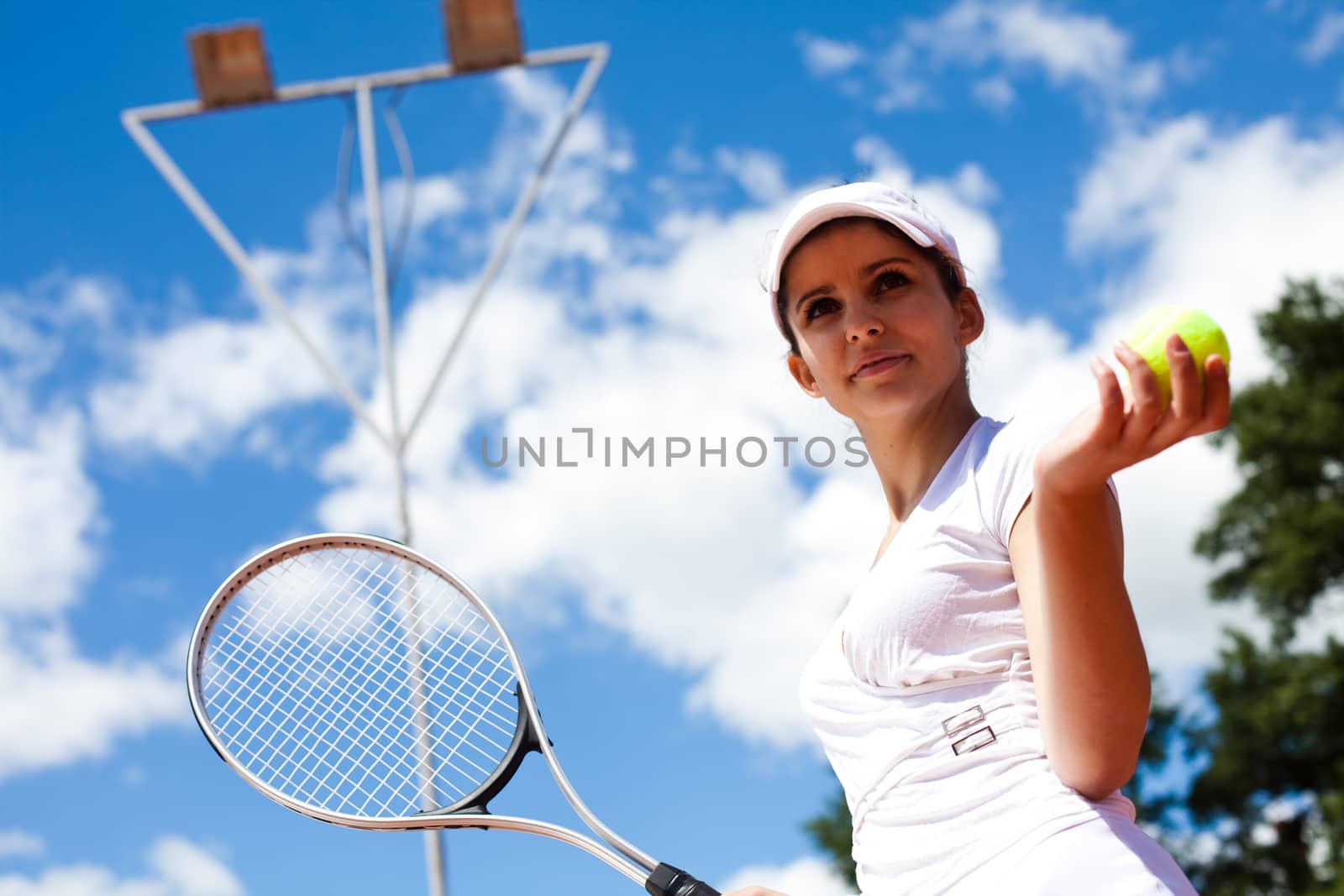 Girl playing tennis on the court by JanPietruszka