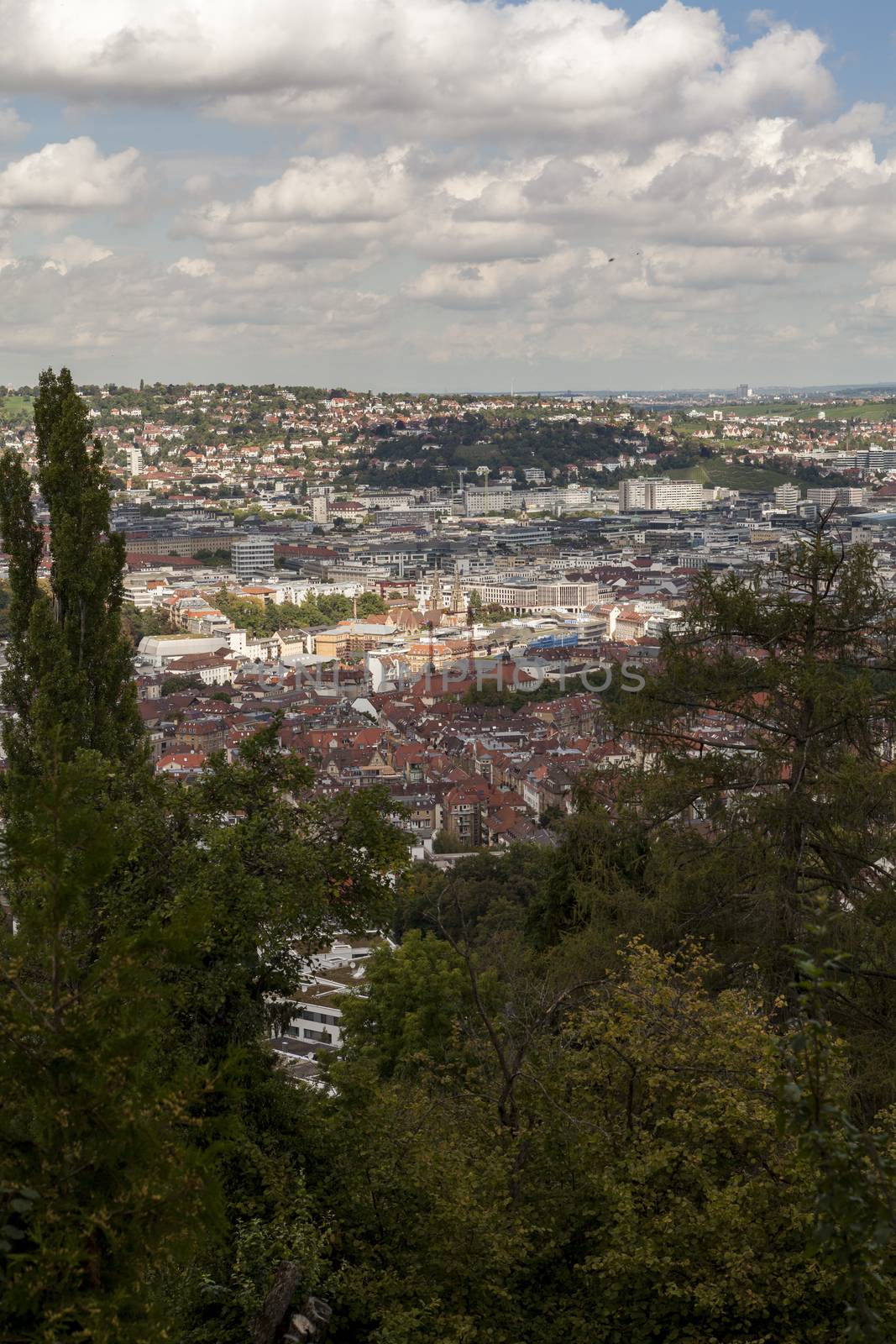 Scenic rooftop view of Stuttgart, Germany showing modern high-rise buildings amongst traditional historical architecture with view to the surrounding hills on a sunny day