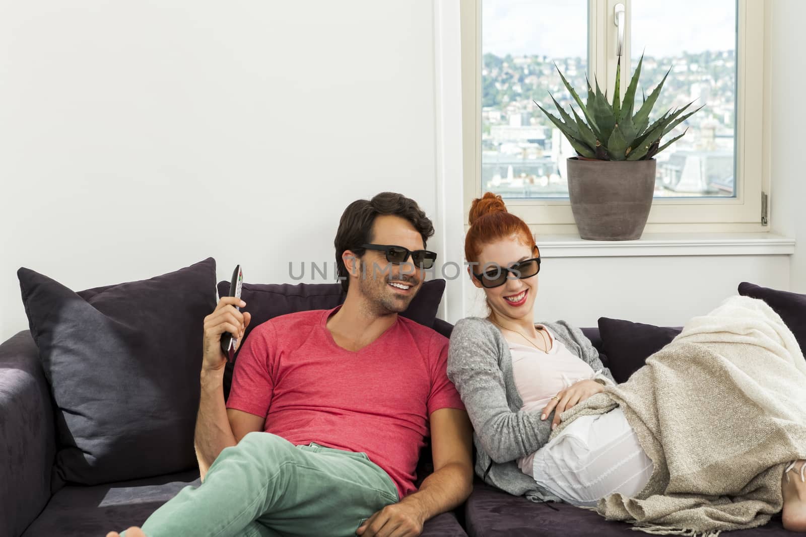 Close up Happy Young Sweethearts Wearing Sunglasses Resting on the Sofa at the House Living Room.