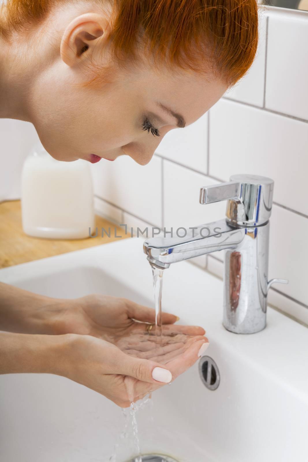 Close up Happy Young Woman Washing her Face While Looking at the Camera for a Moment.