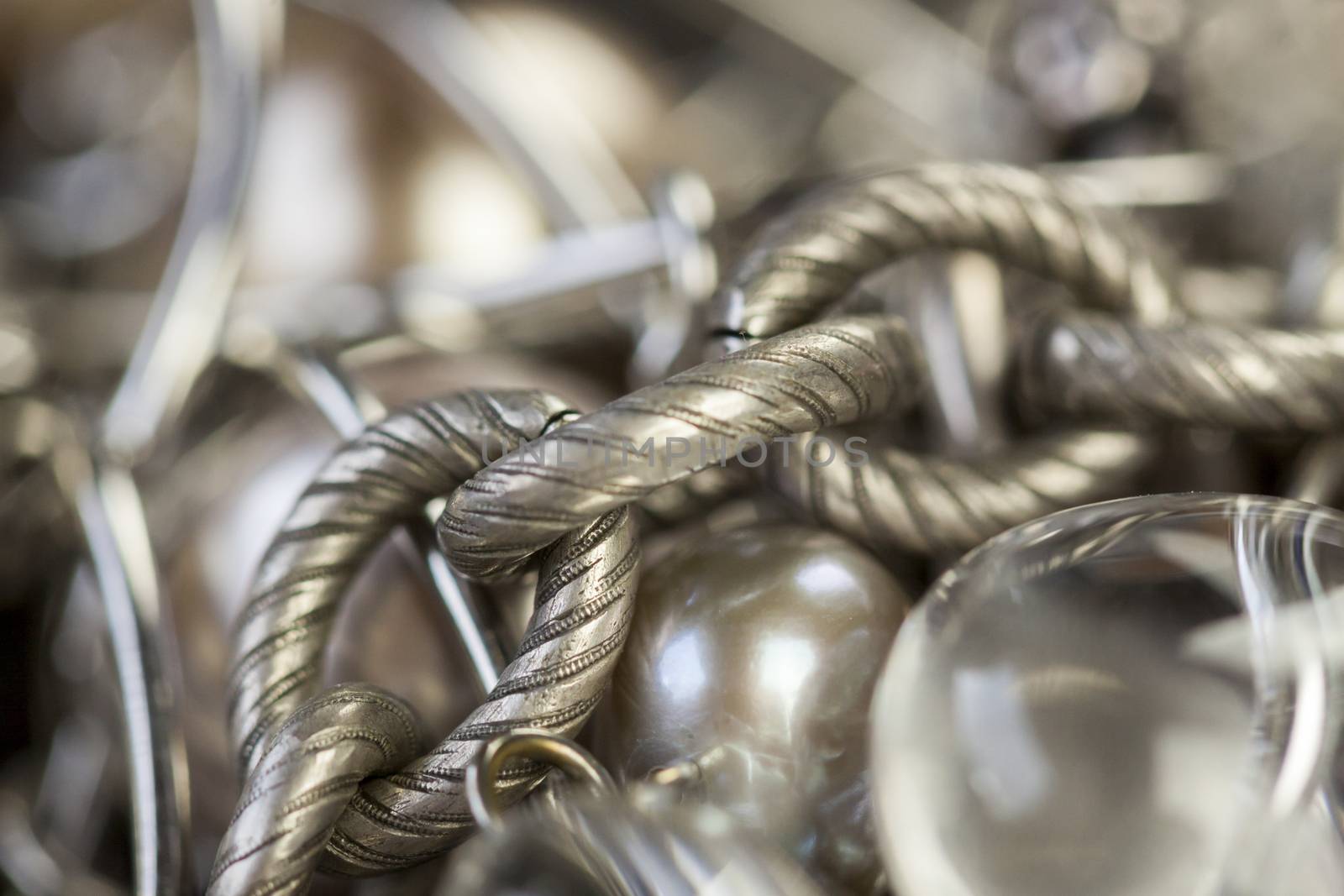 Close up of three attractive shiny purple beads attached by silver chains on an item of jewellery in a fashion and handicraft concept