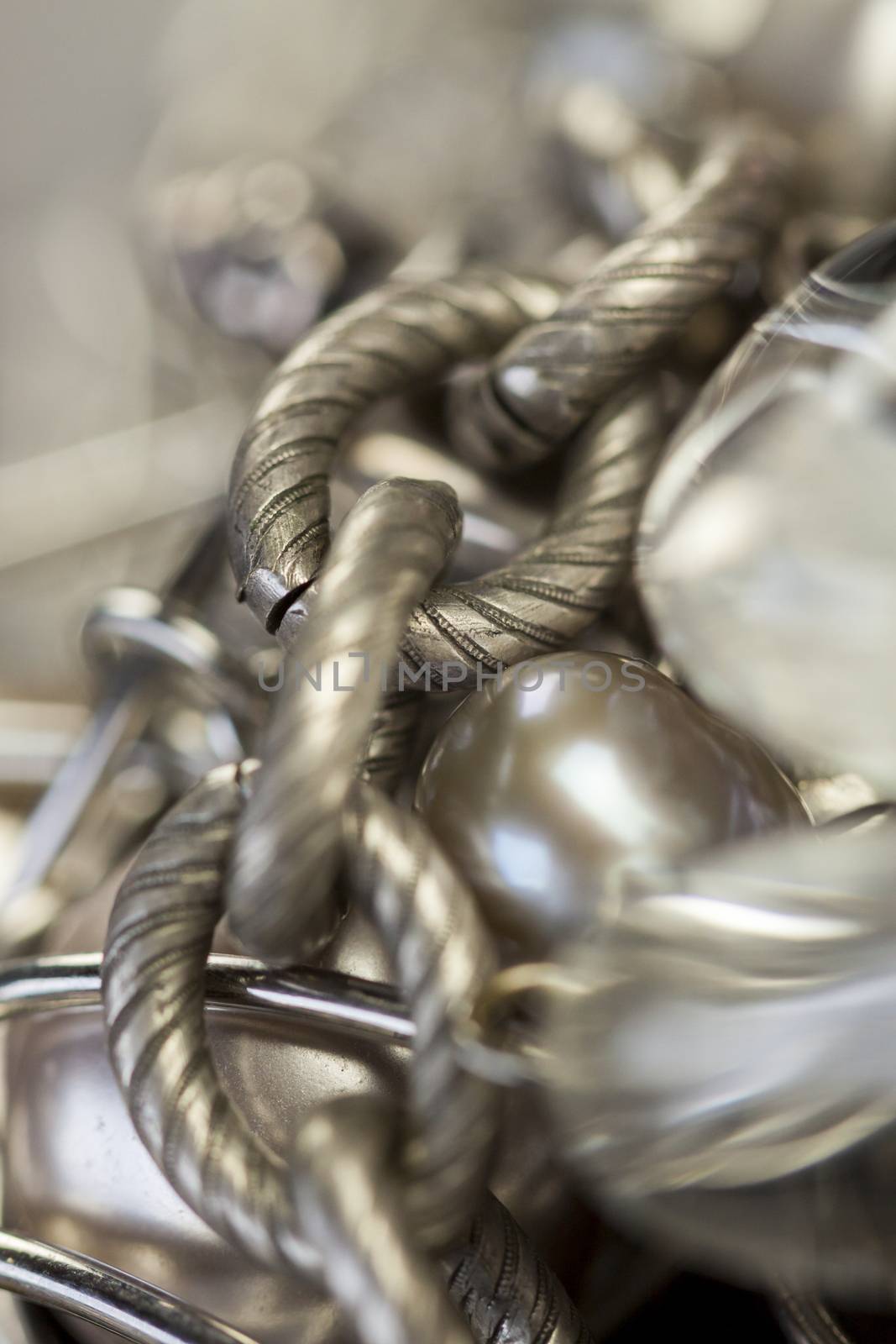 Close up of three attractive shiny purple beads attached by silver chains on an item of jewellery in a fashion and handicraft concept