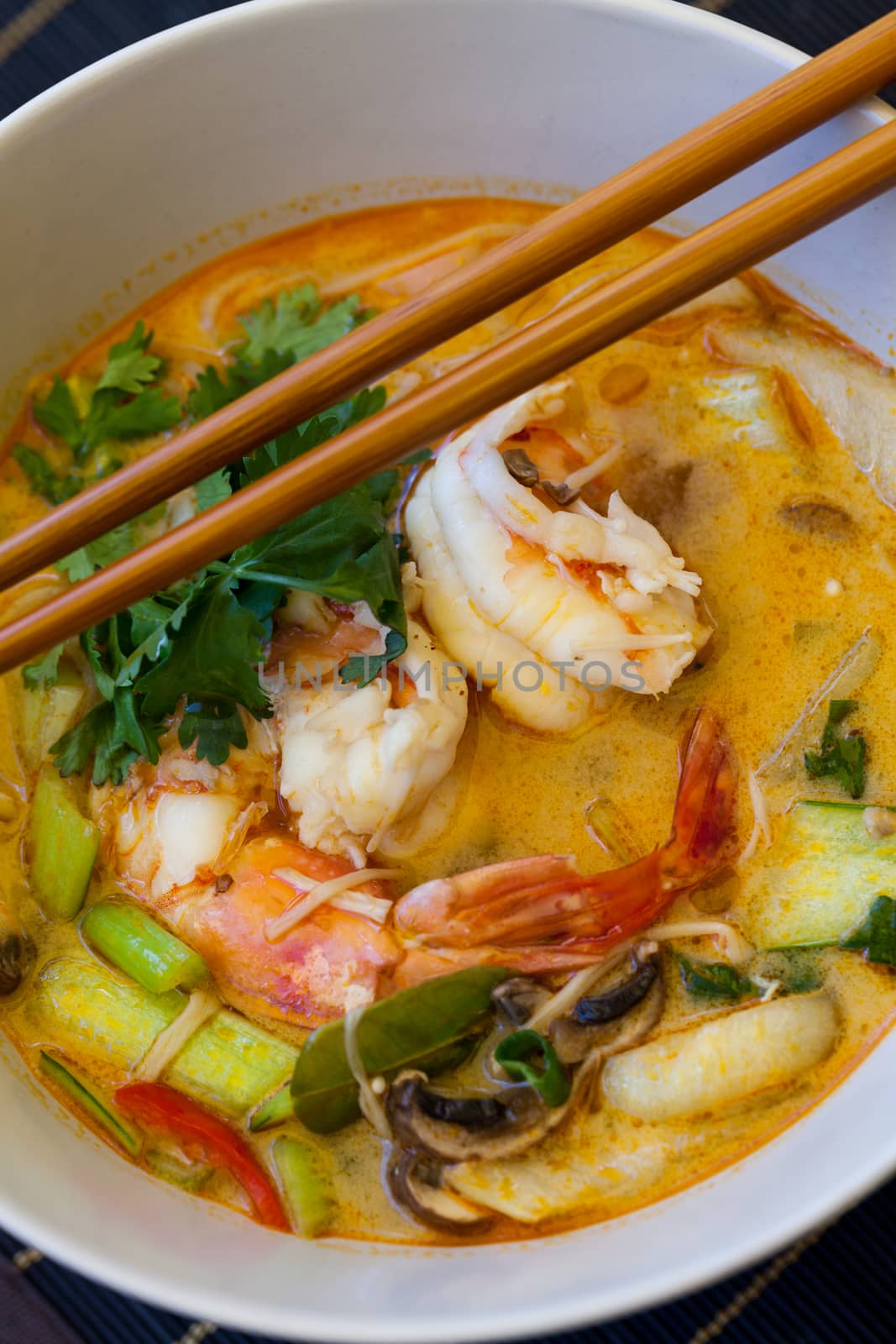 Bowl of traditional Thai tom yam soup by juniart