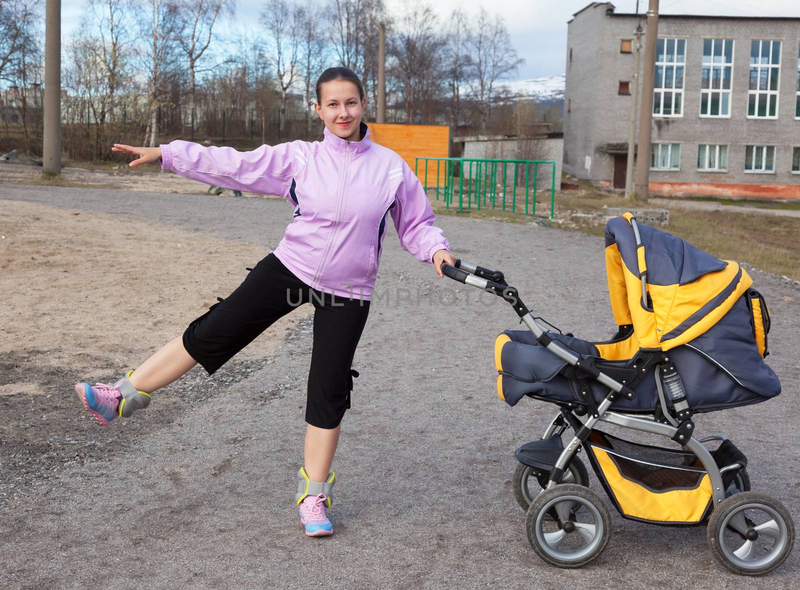 a young mother with a toddler combines walk in a stroller fitness