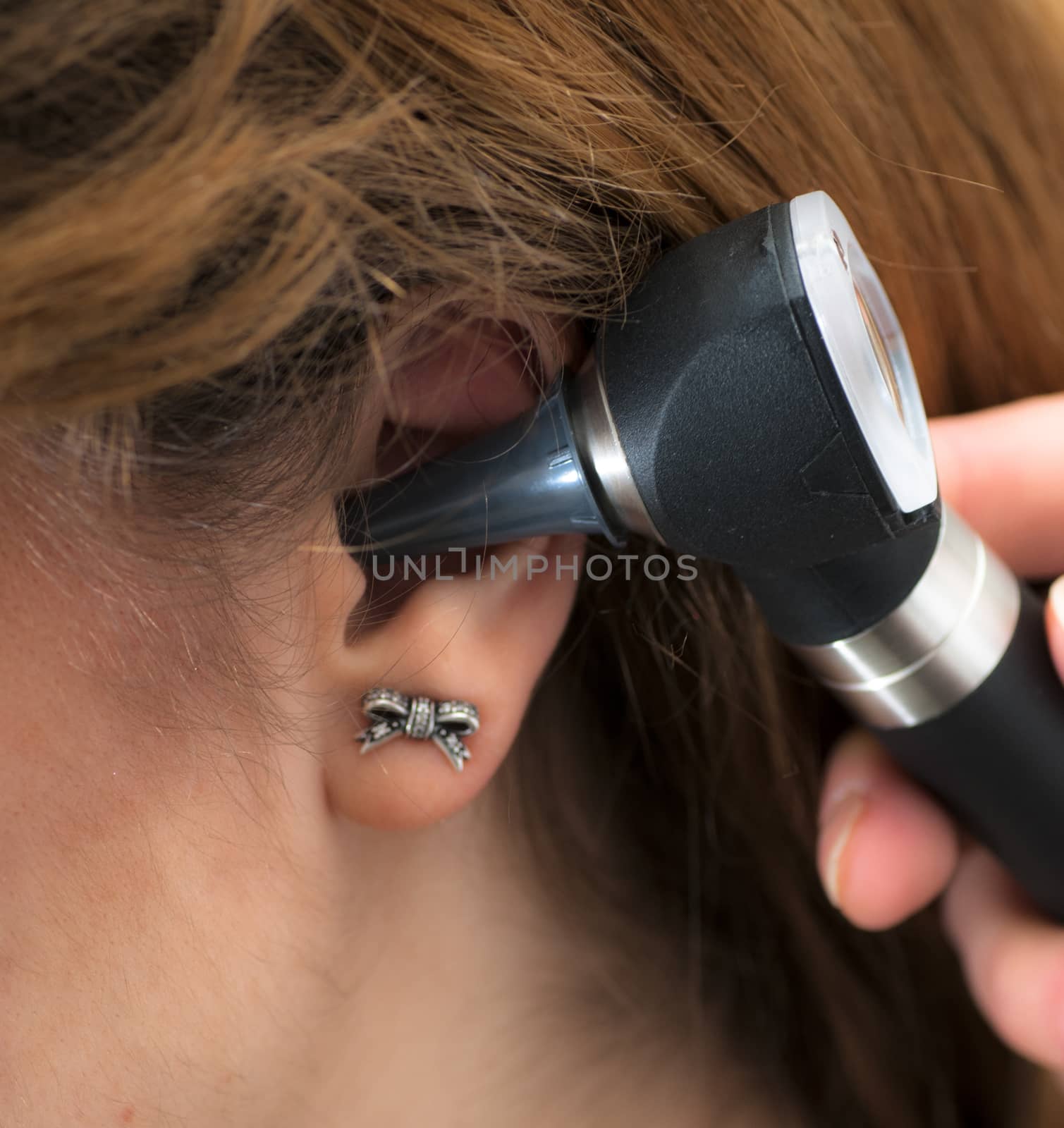 doctor checking patient's ear with otoscope