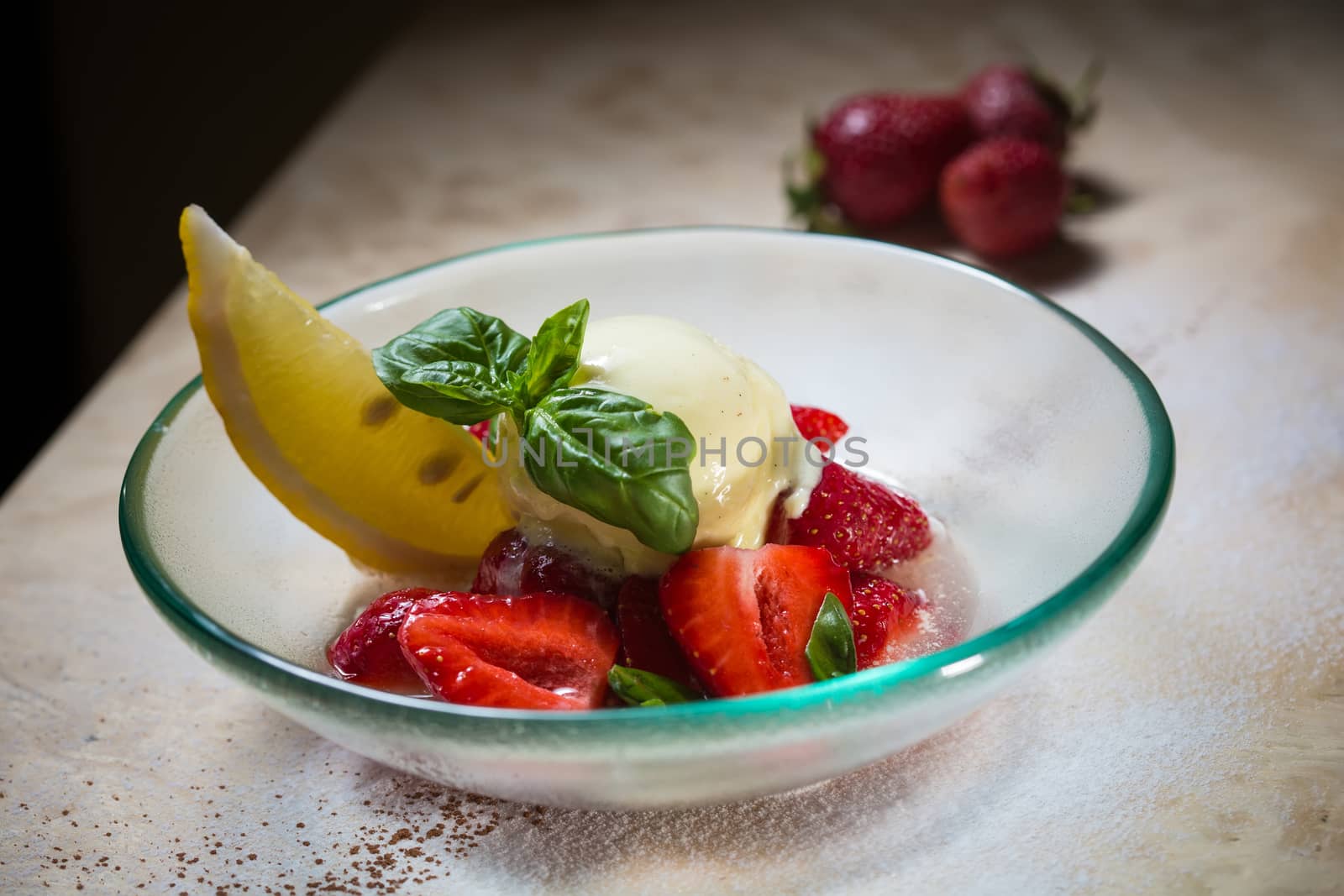 Ice cream with fresh strawberries in glass bowl